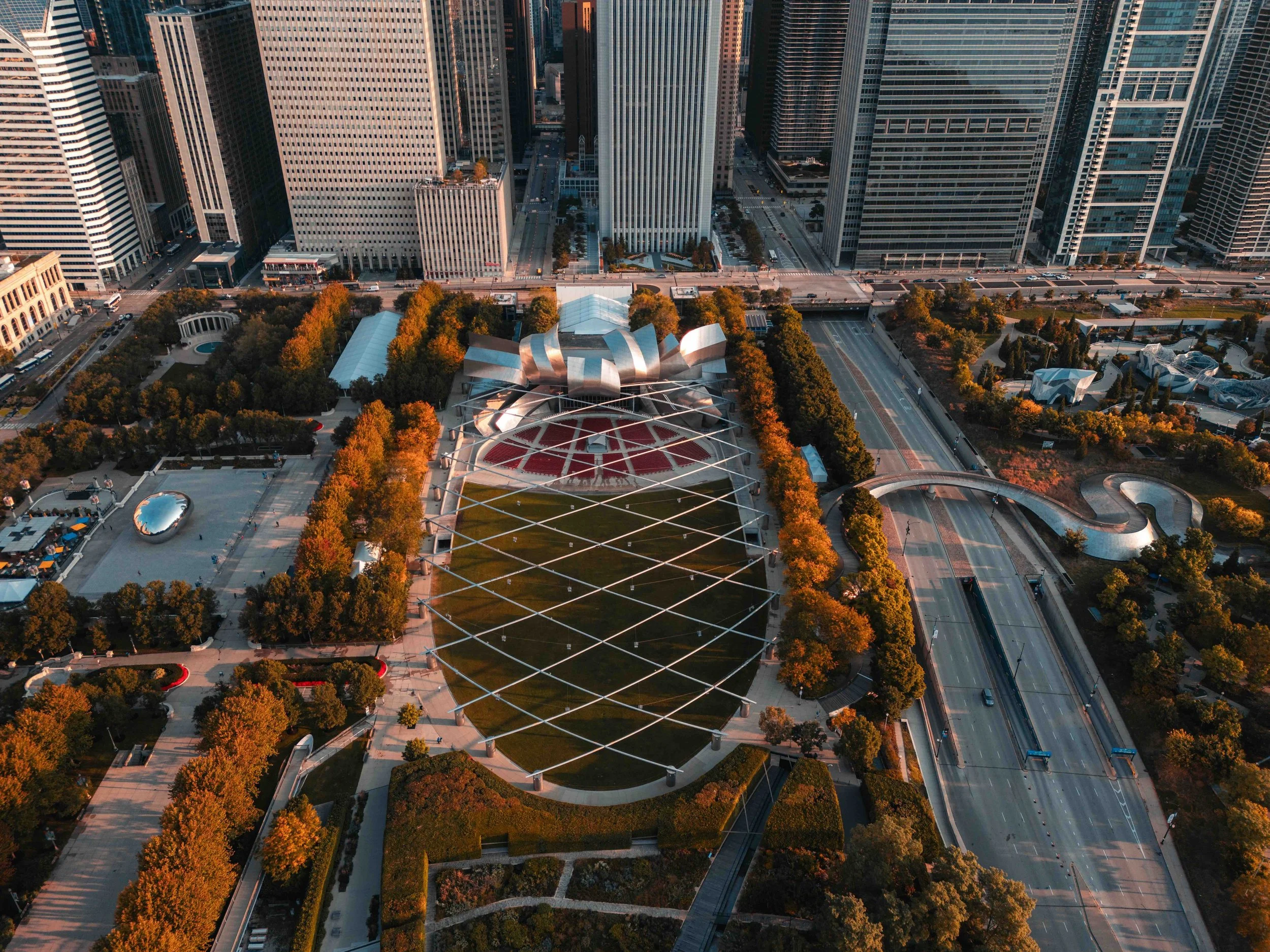 An aerial shot of Millenium park and the tall buildings of Chicago in the background.