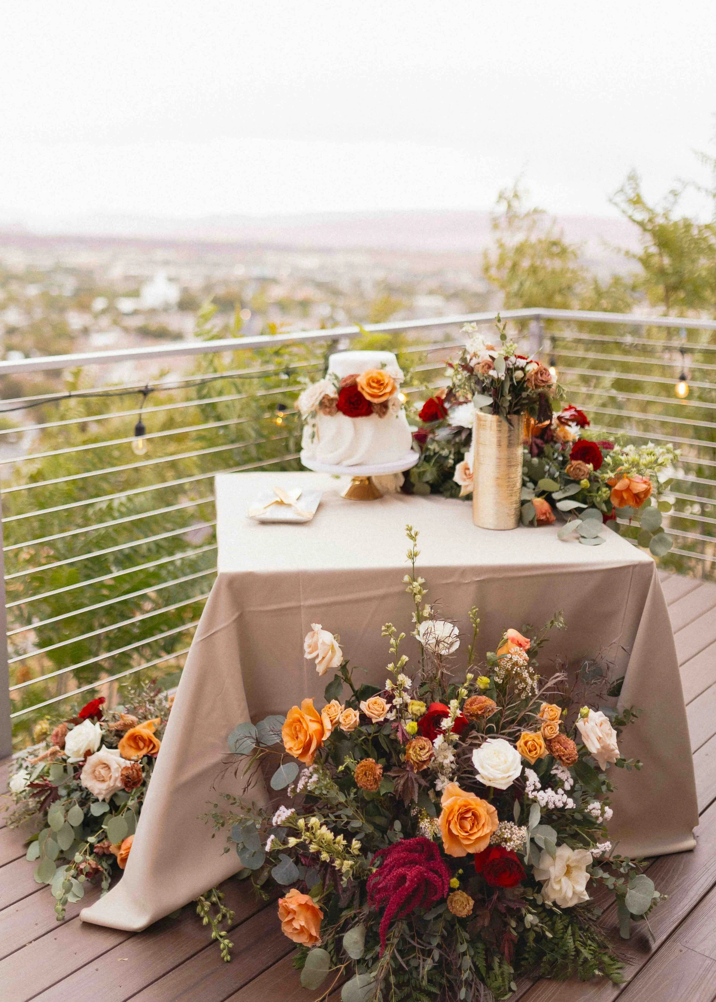 a cake on a table with flowers around it.