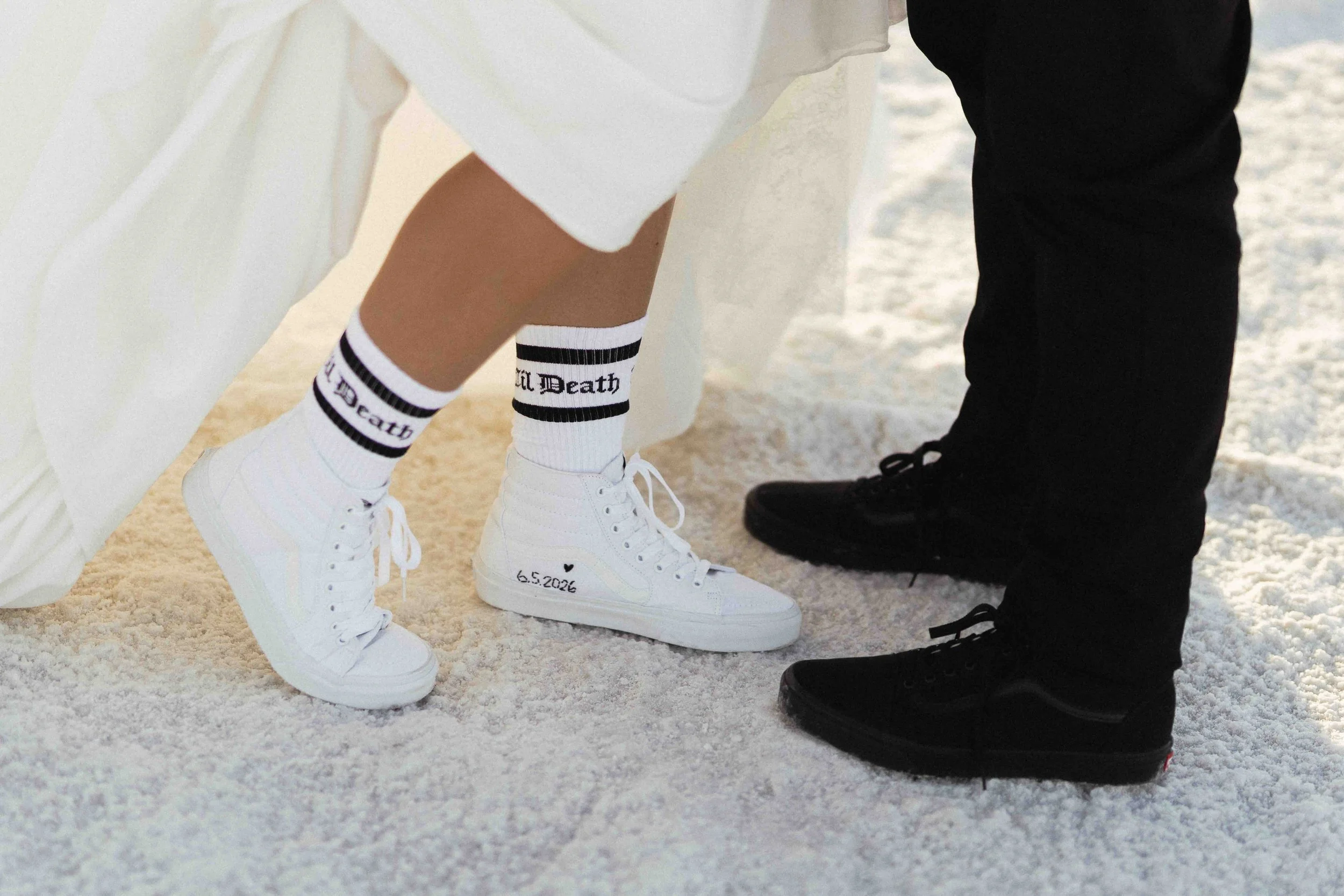 Wedding shoes that are vans. White on the bride and black on the groom.