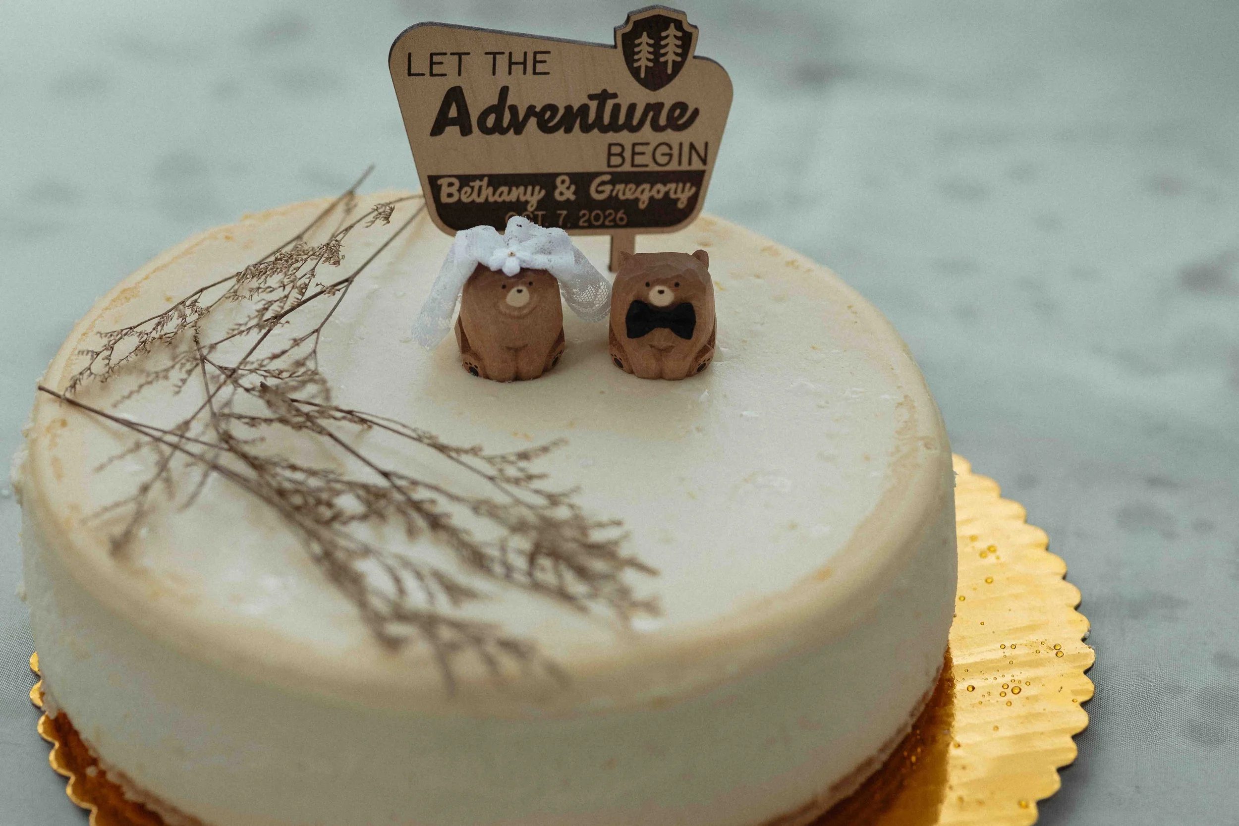 A cheesecake with little bear bride and groom toppers.