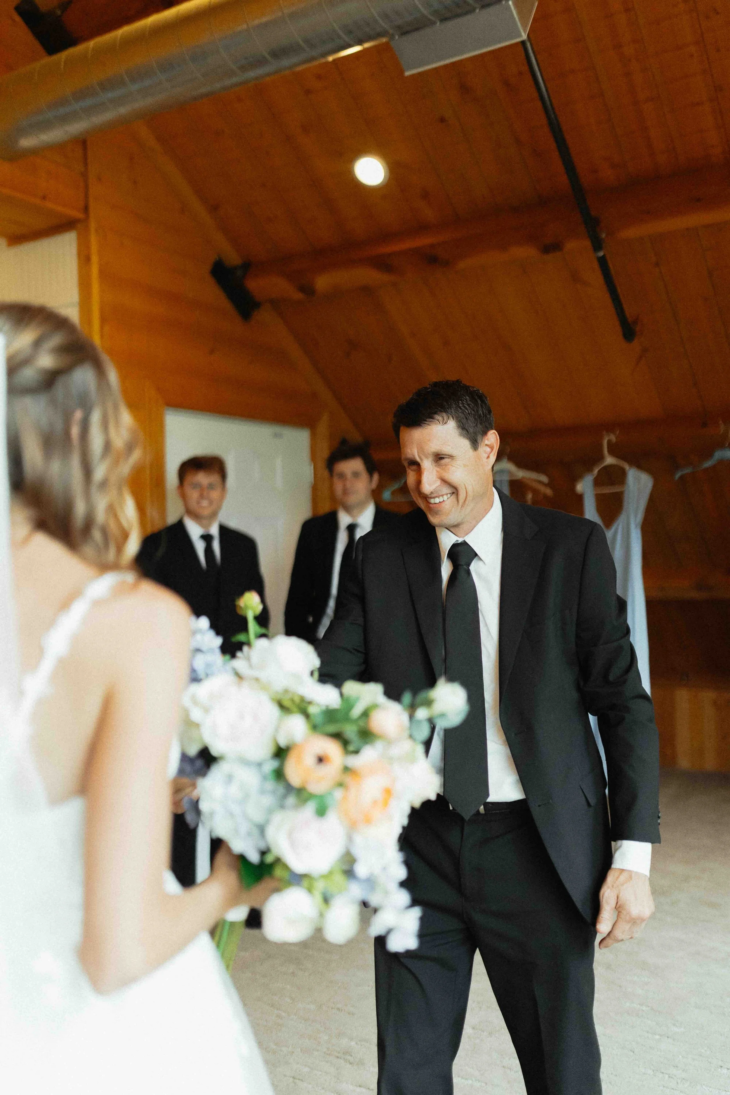 Bride having a first look with her father in a rustic barn.