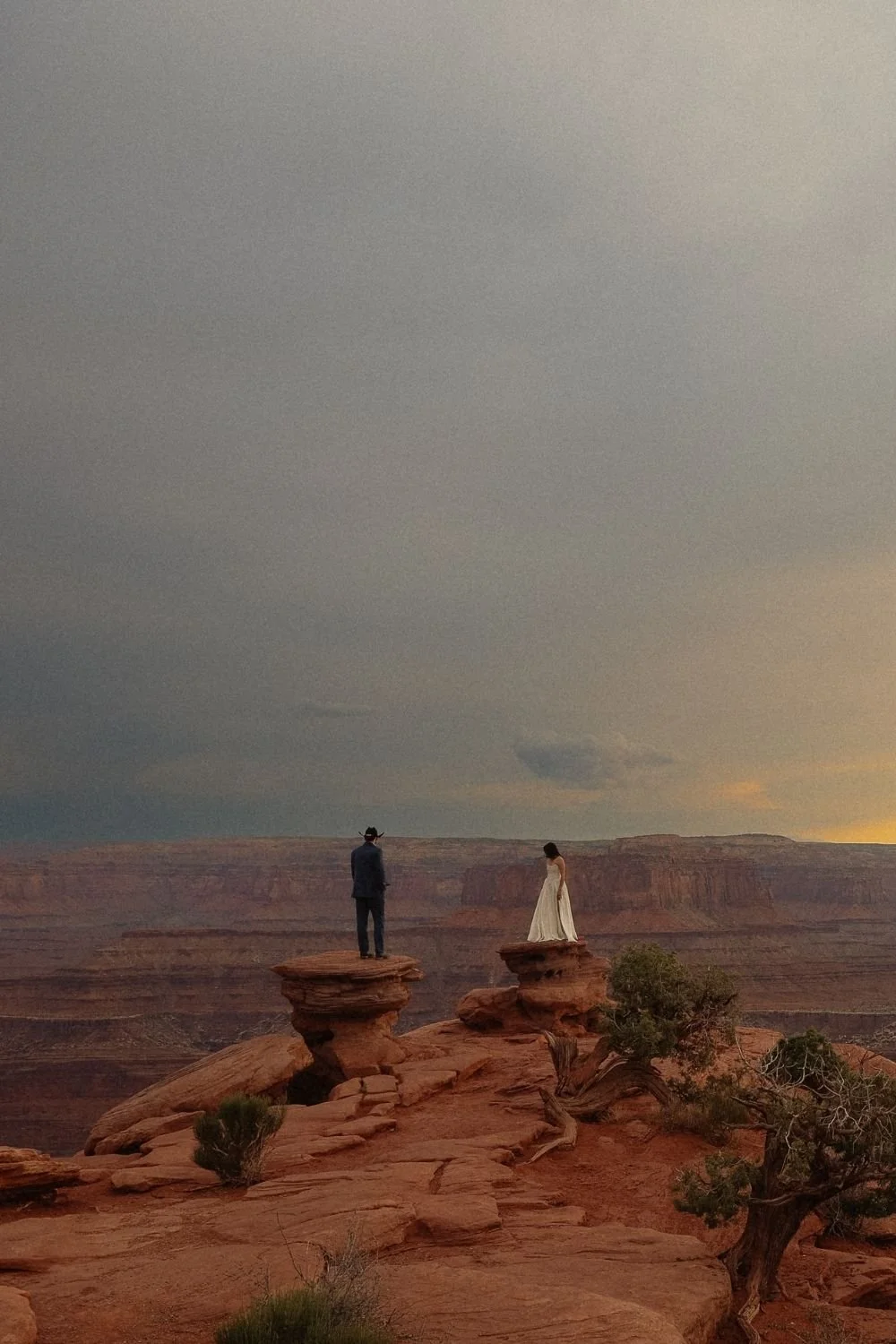 bride and groom standing on red rocks of Moab Utah.