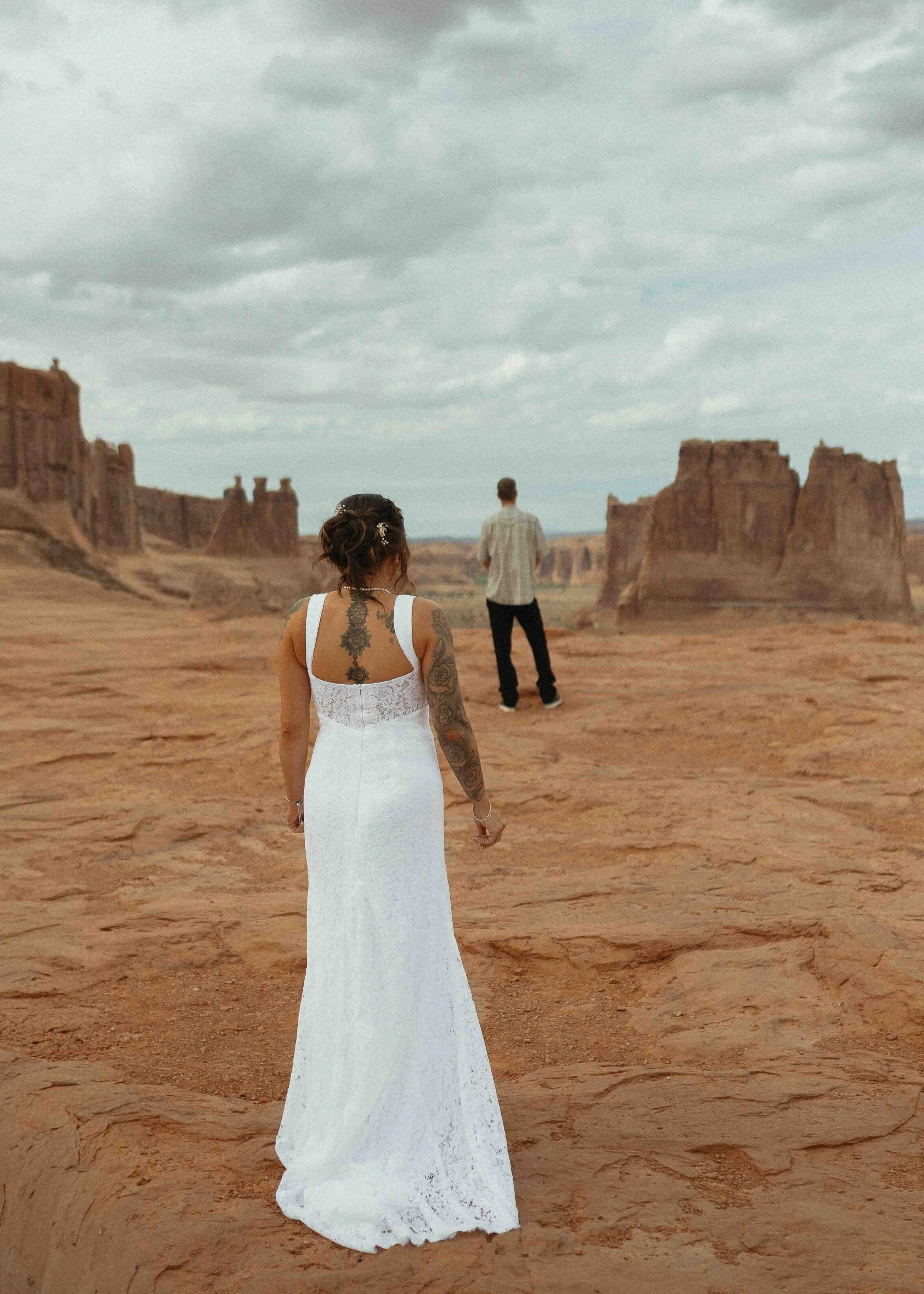 Bride about to do a first look with her groom in front of red rock formations in Utah.
