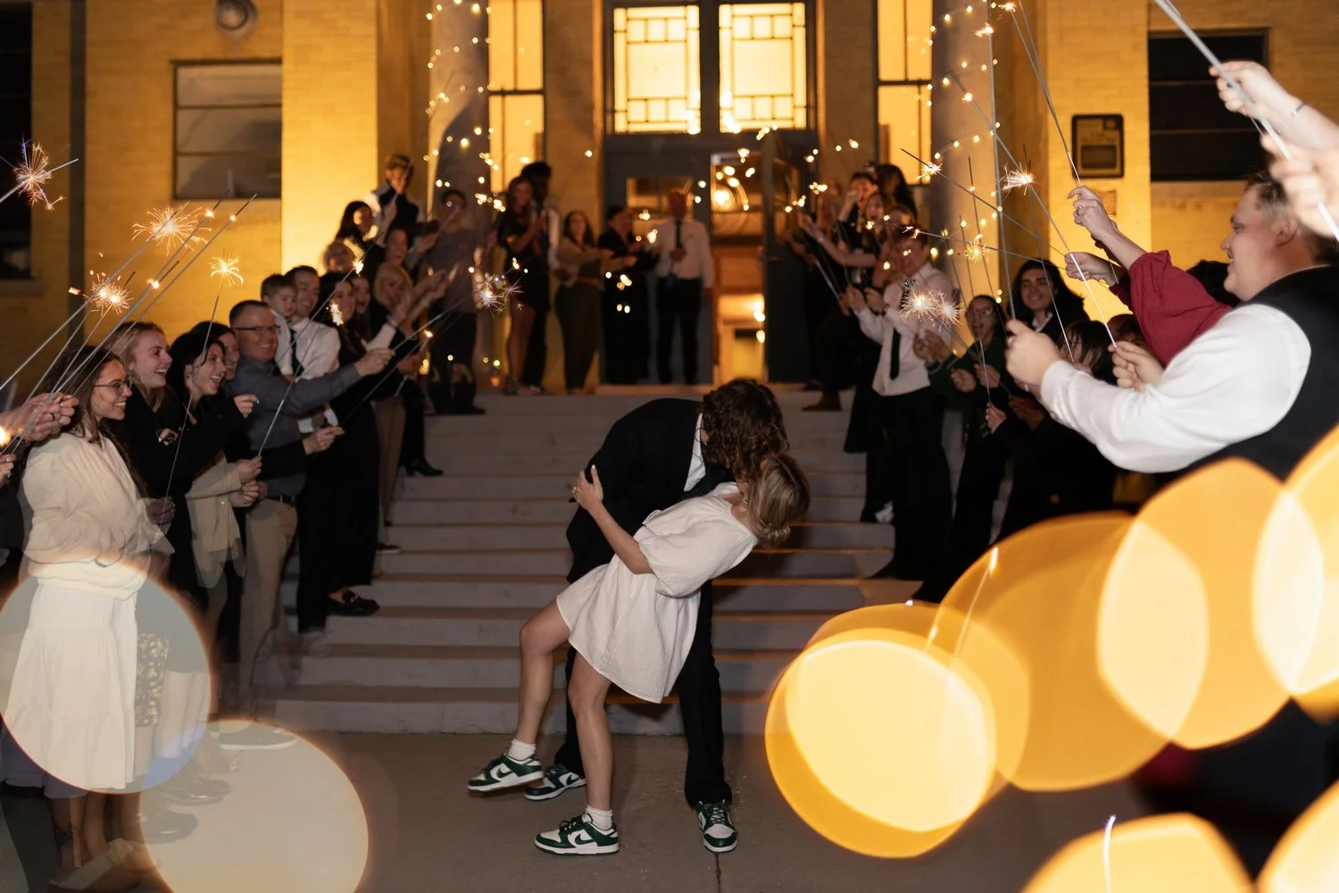 Bride and groom kissing and dipping in their sparkler exit of their wedding.