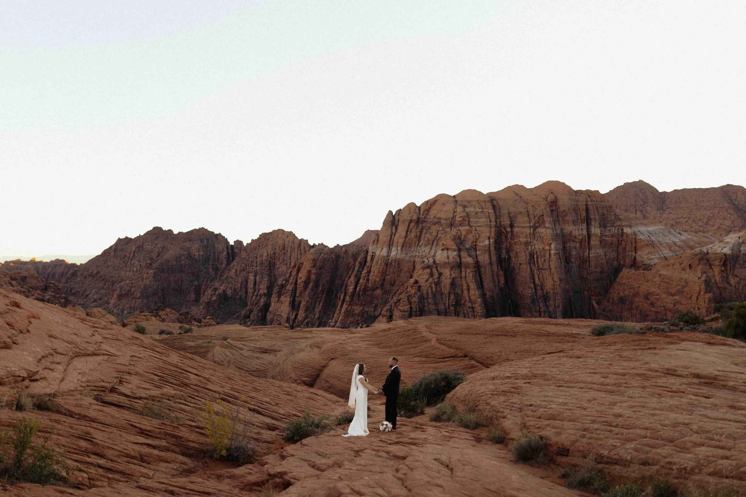 Bride and groom holding hands at Snow Canyon State Park in St. George, UT.