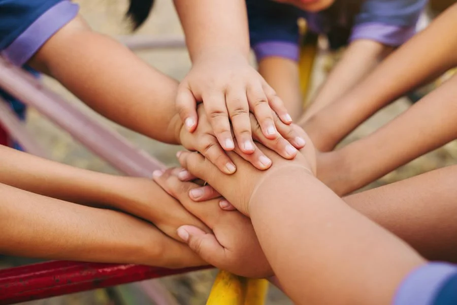 Children’s hands stacked together at Pike Market Childcare and Preschool in downtown Seattle, celebrating a successful annual fundraising appeal.