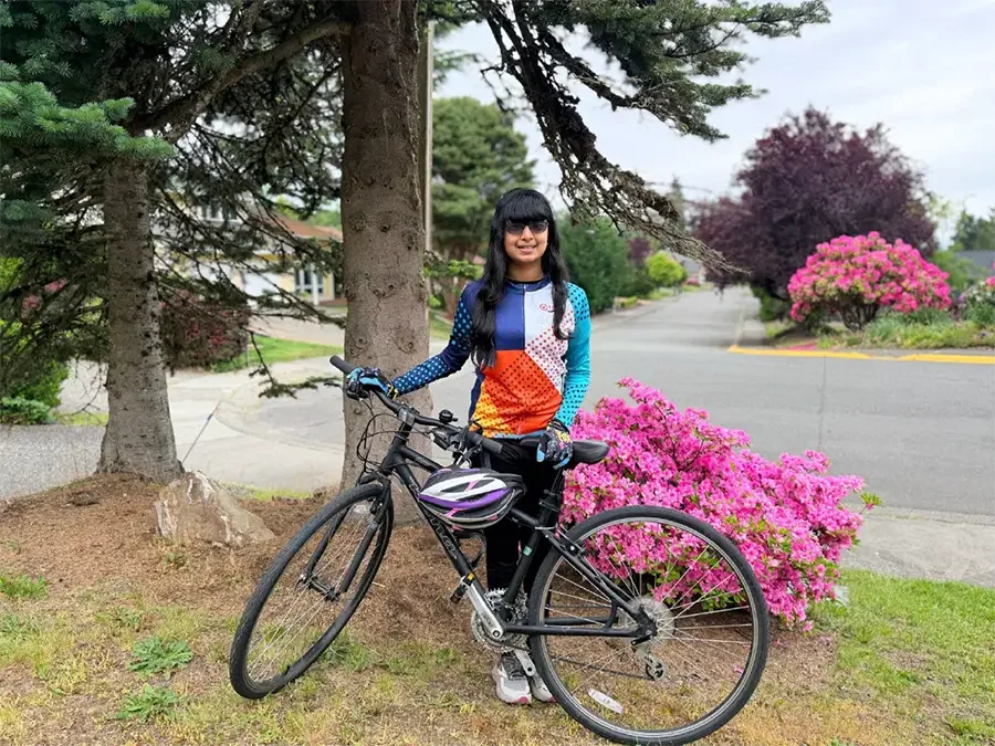 Former PMCCP student, Shrimayi, standing by her bike