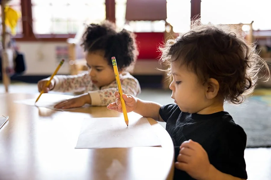 Two toddlers learning to write with pencils. Photo by Jenny Jimenez