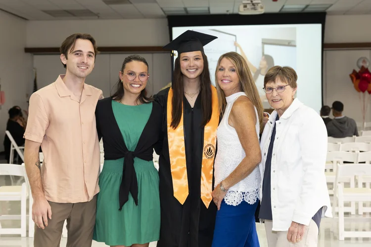Sentio University MFT graduate Olivia Ng with family at the 2026 commencement ceremony