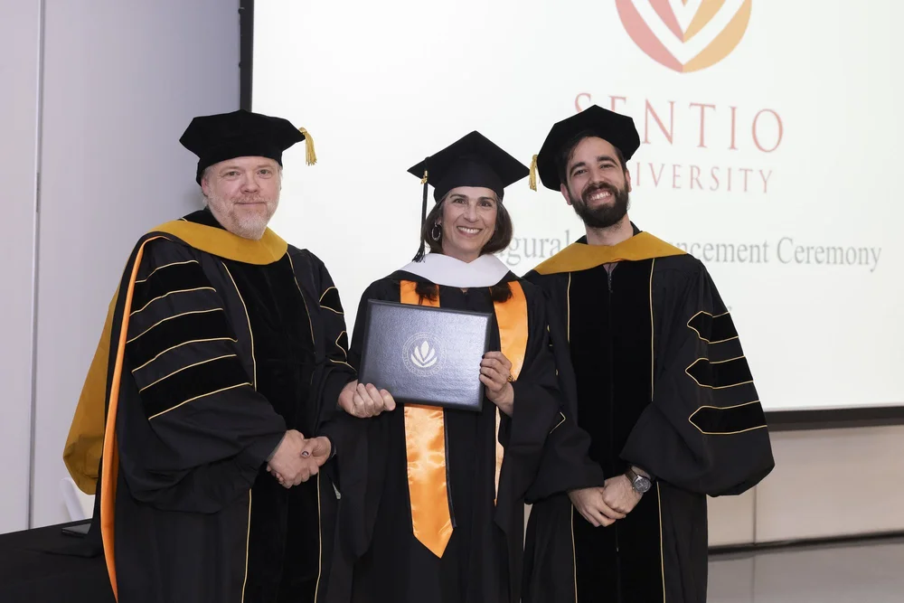 Sentio MFT graduate Rachel Ostroy with faculty at the 2026 commencement ceremony