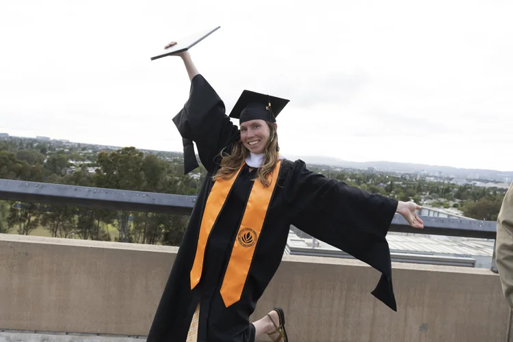 A Sentio MFT graduate celebrating in cap and gown