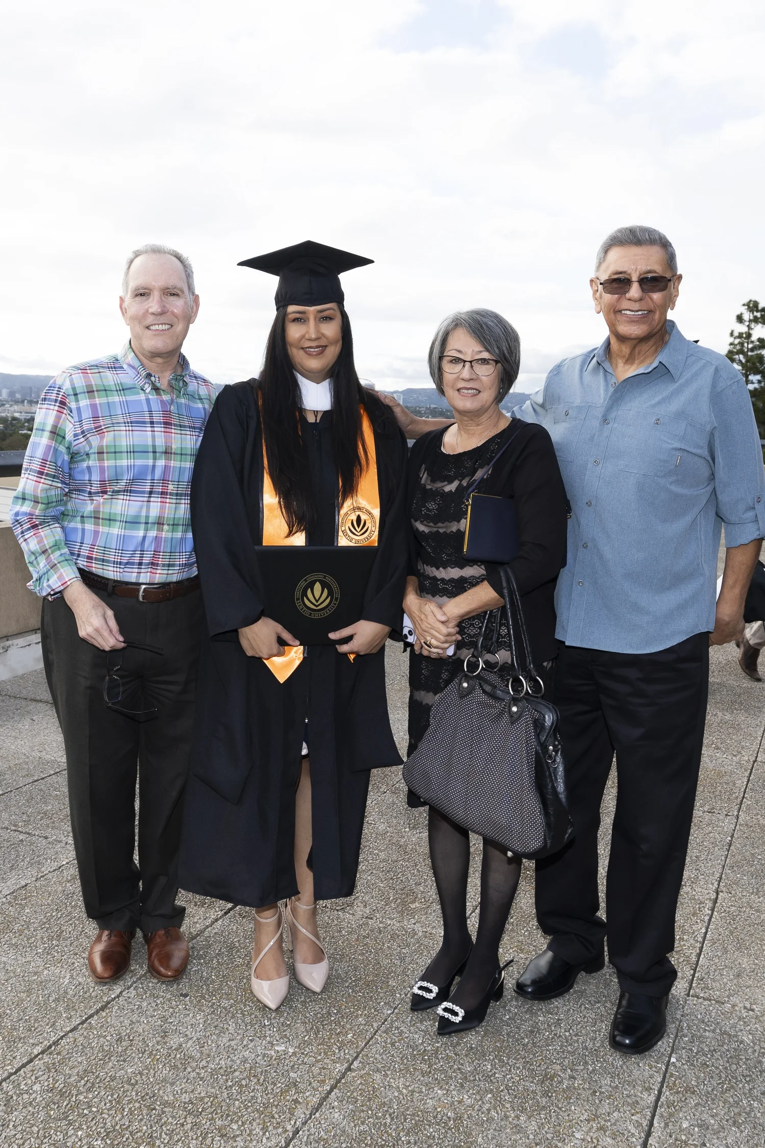 Sentio University MFT graduate Victoria Gonzales with family at the 2026 commencement ceremony