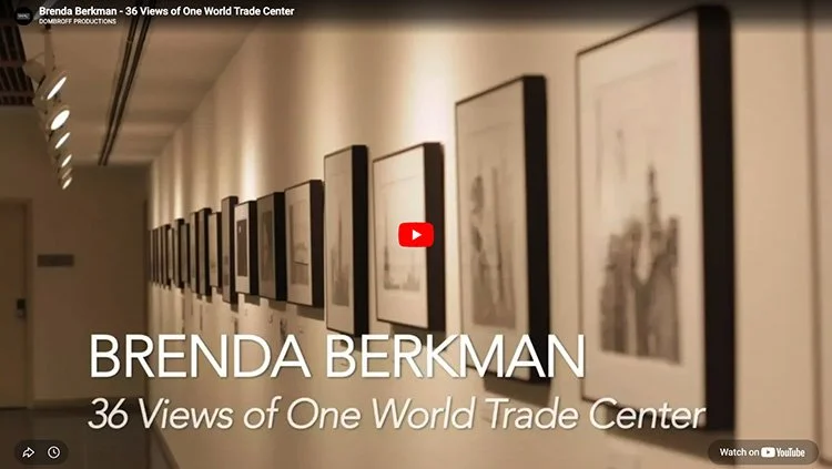 An art gallery with framed sketches or photos hanging on a wall, with the title overlay "Brenda Berkman - 36 Views of One World Trade Center."