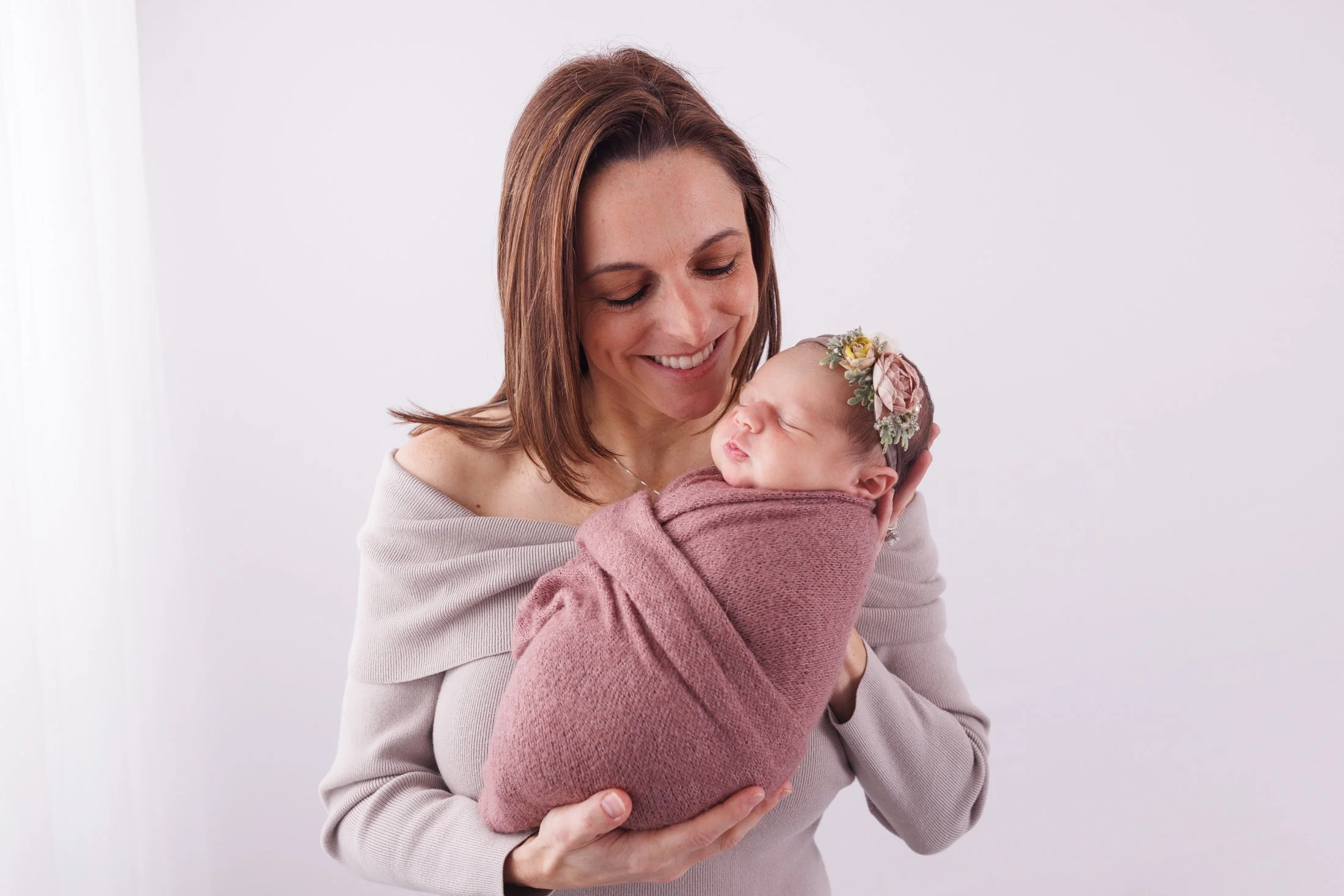 Mom looking and smiling at newborn baby in her arms