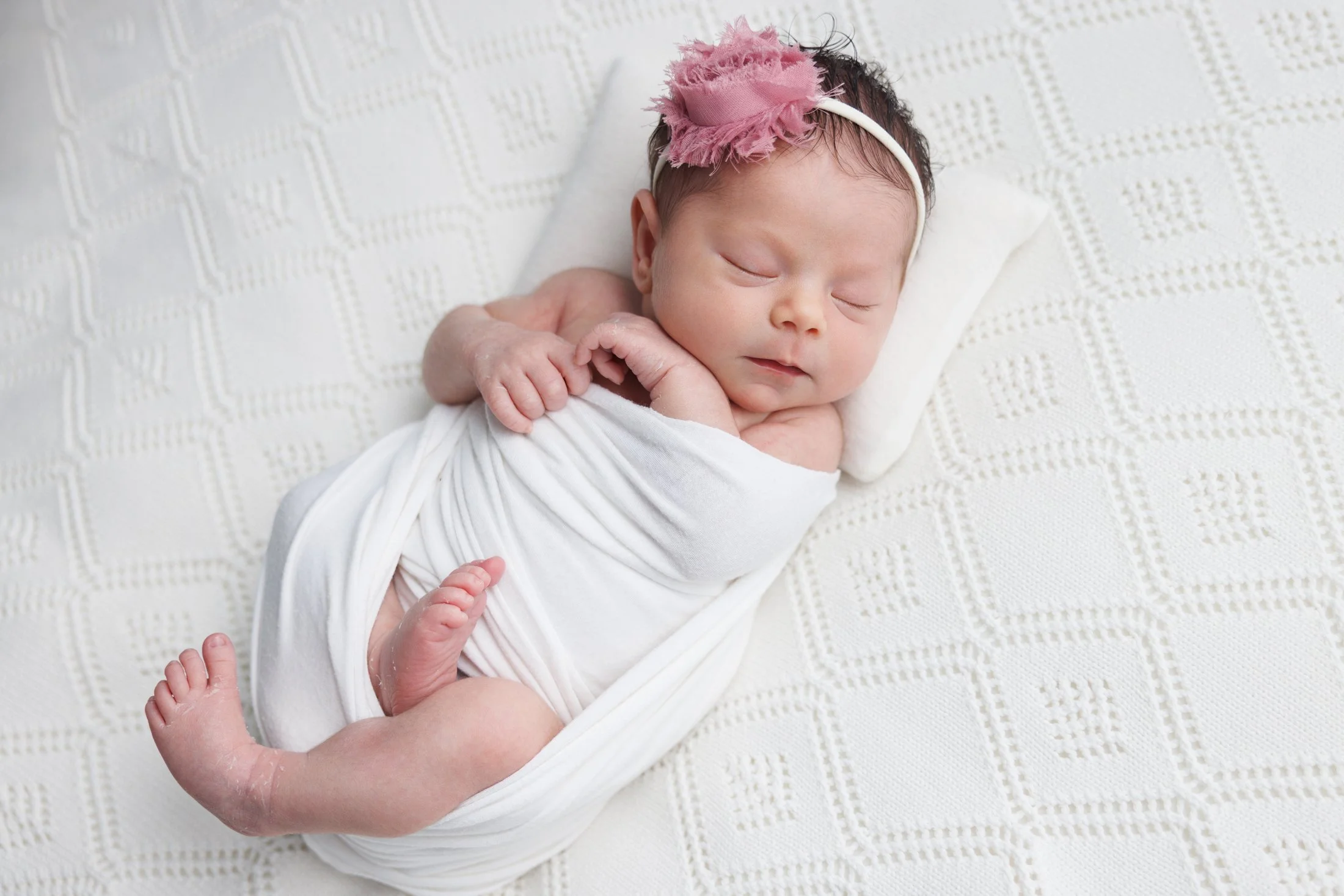 newborn on white blanket