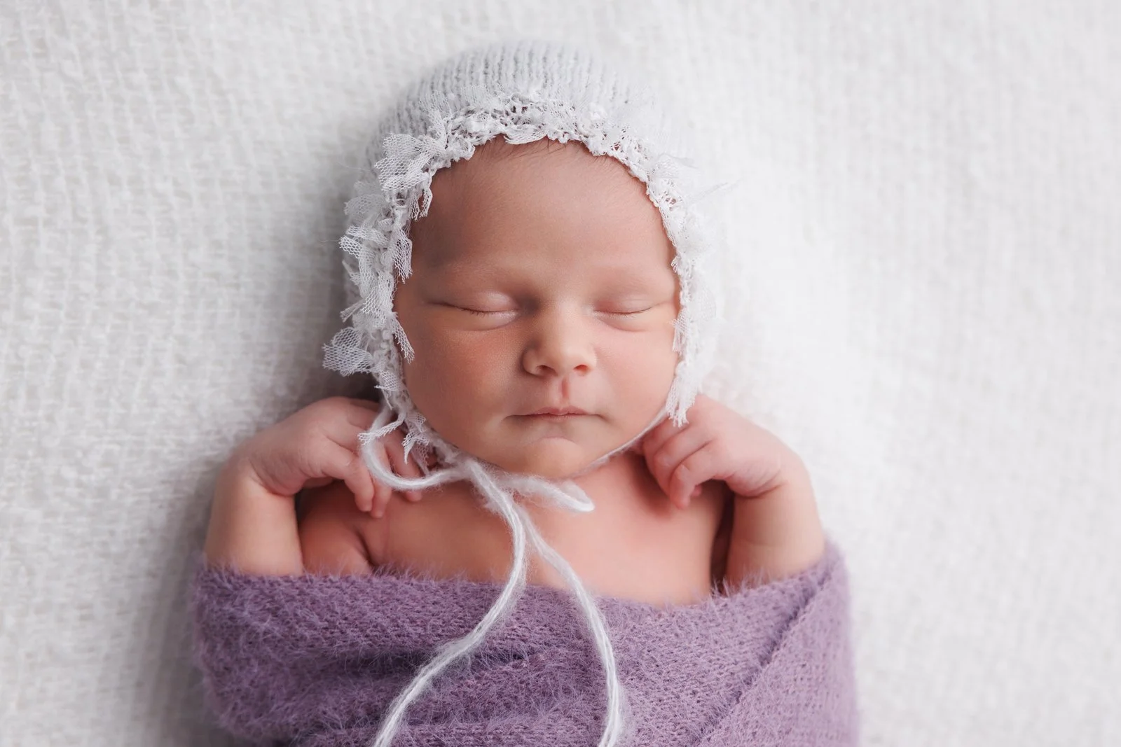 newborn baby wrapped in purple