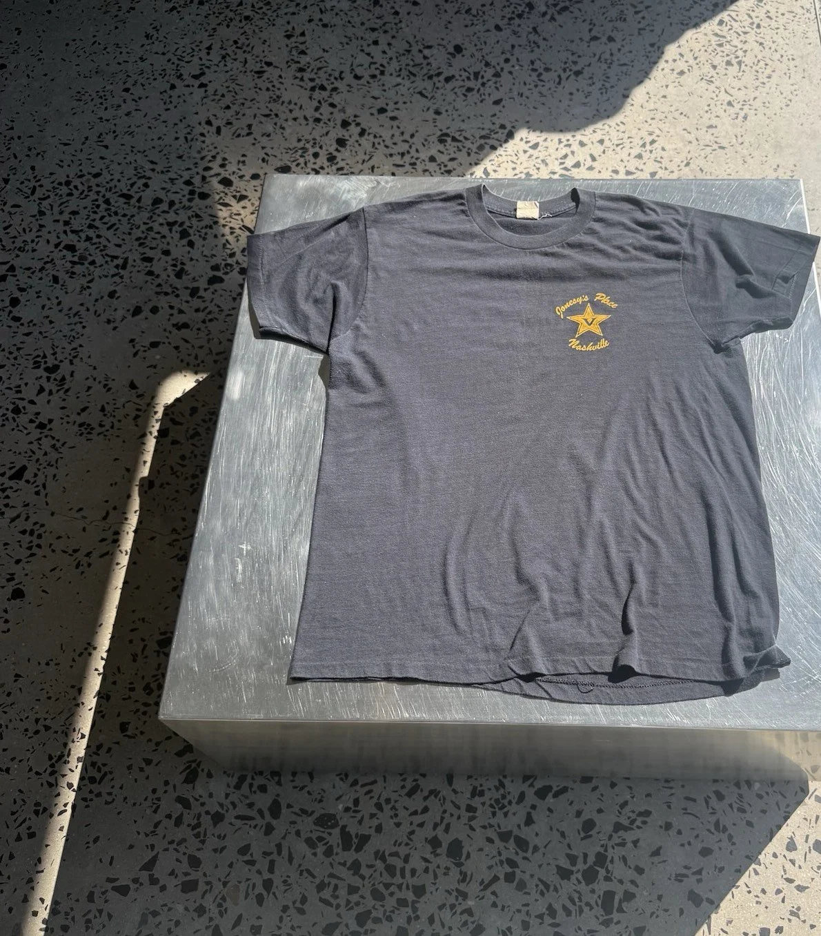 Vintage faded black Jonesy's Place Nashville t-shirt laid flat, full front view