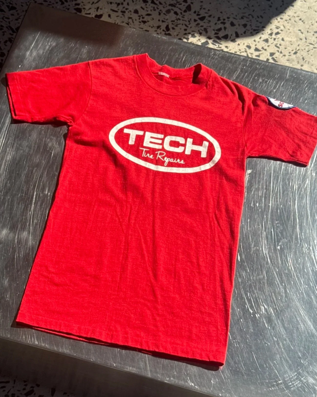 Vintage 80s Tech Tire Repairs red t-shirt laid flat showing front print