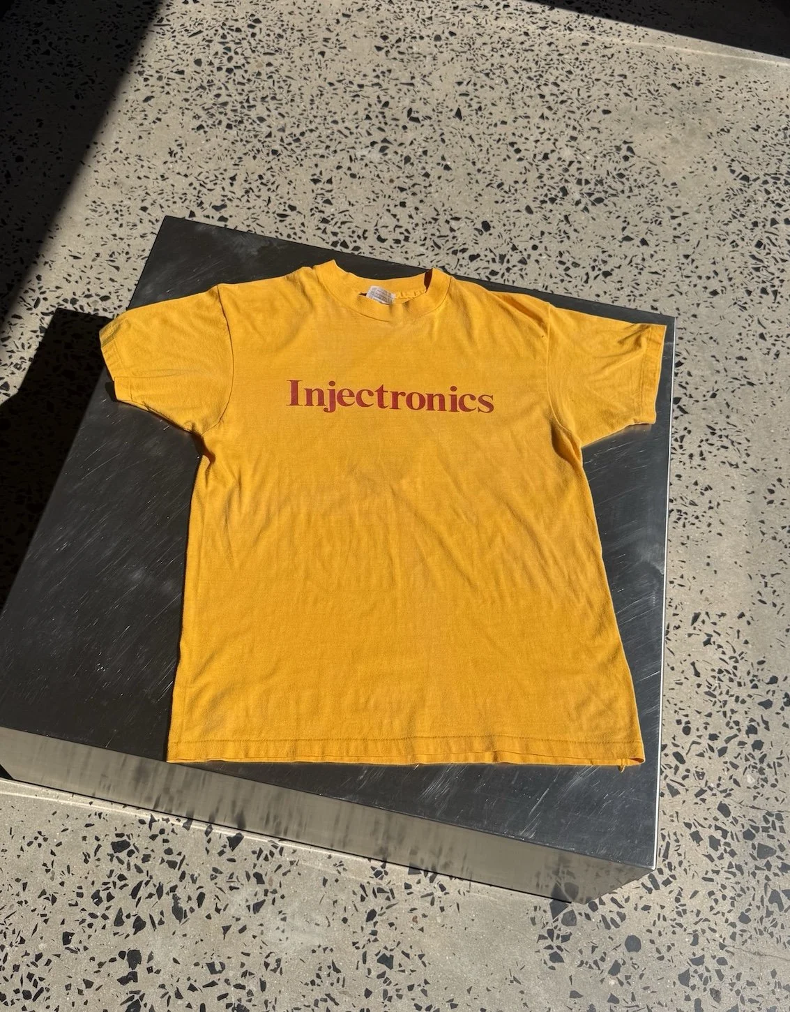 Vintage 80s yellow Injectronics t-shirt laid flat showing full front print