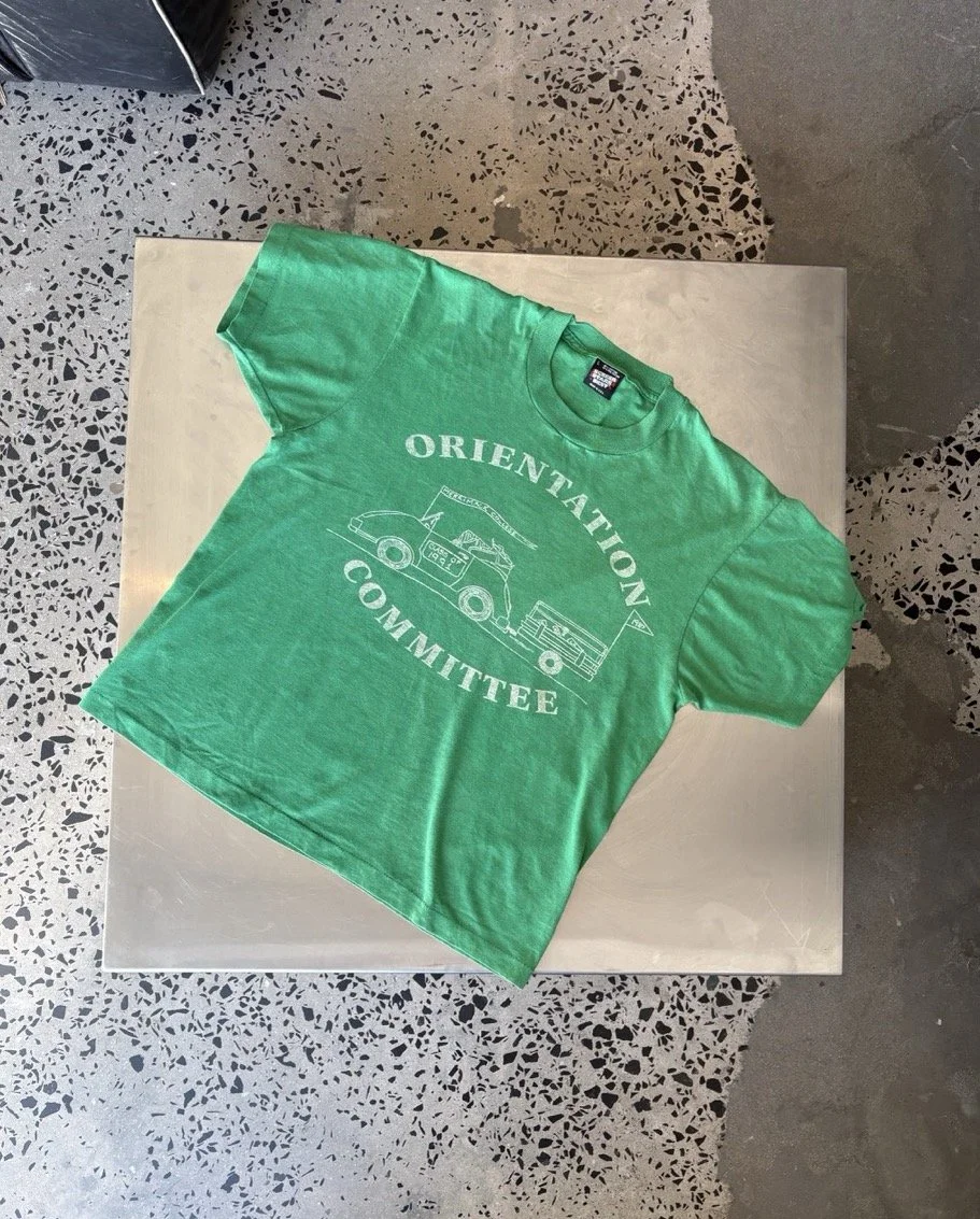 Vintage green Orientation Committee t-shirt laid flat, front view