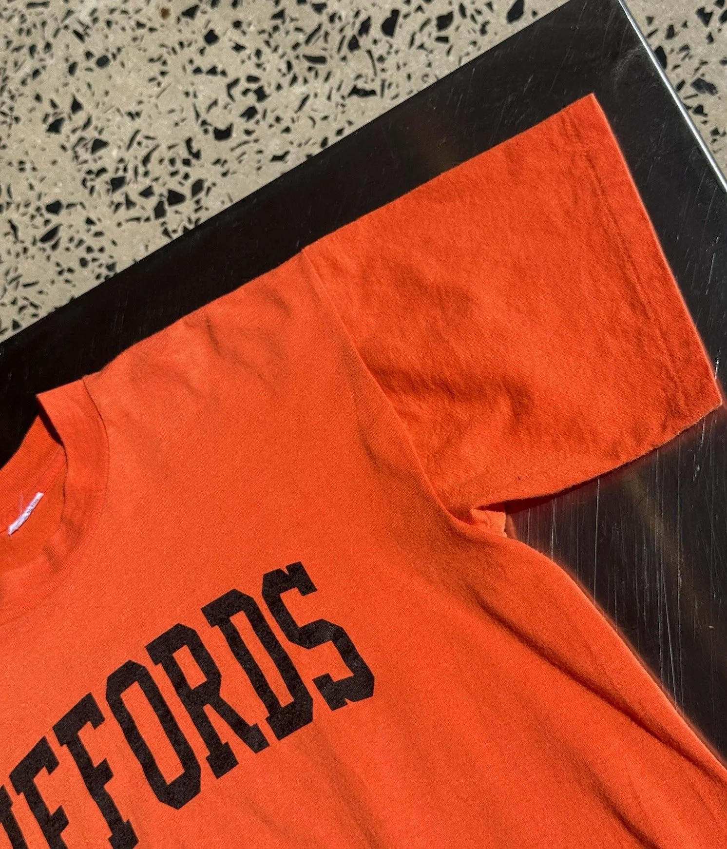 Shoulder and sleeve detail of vintage 80s orange Giffords t-shirt
