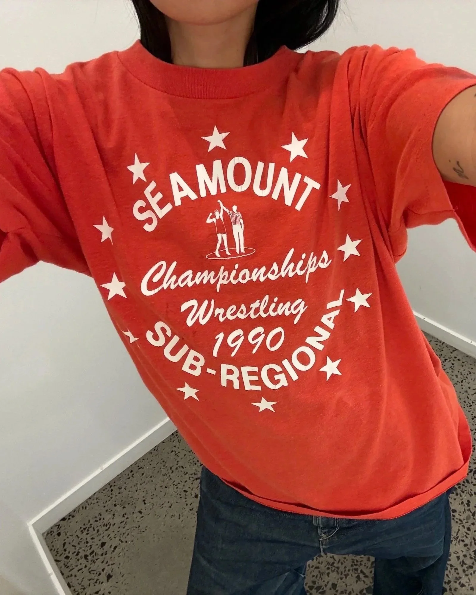 Close-up of Seamount Sub-Regional Wrestling Championships 1990 star-ringed print on faded red t-shirt