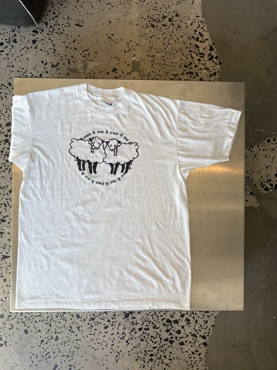 Close-up of sheep print, repaired hole and Hanes Fifty-Fifty neck label on vintage white t-shirt