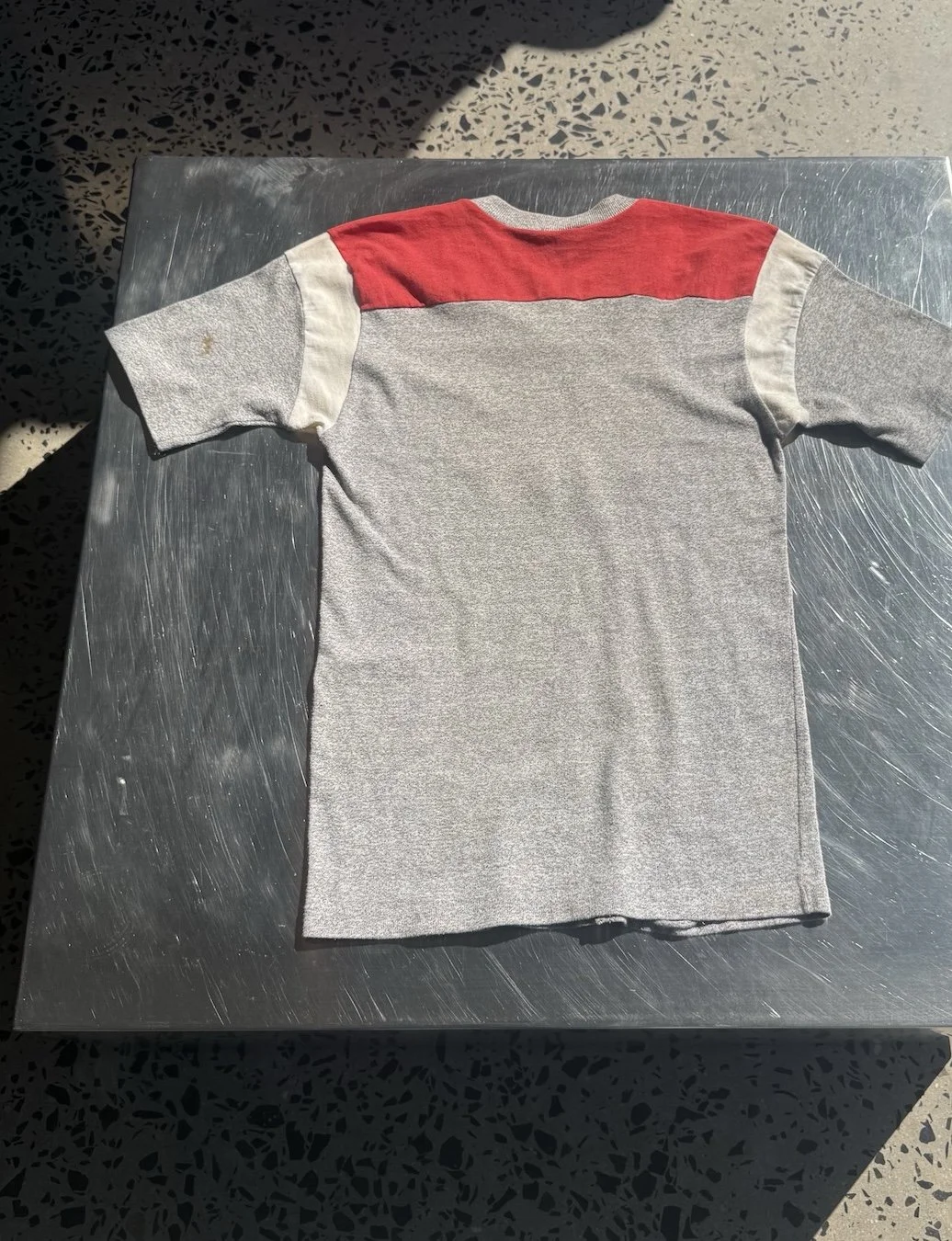 Vintage grey and red ICA jersey t-shirt laid flat, back view showing red yoke