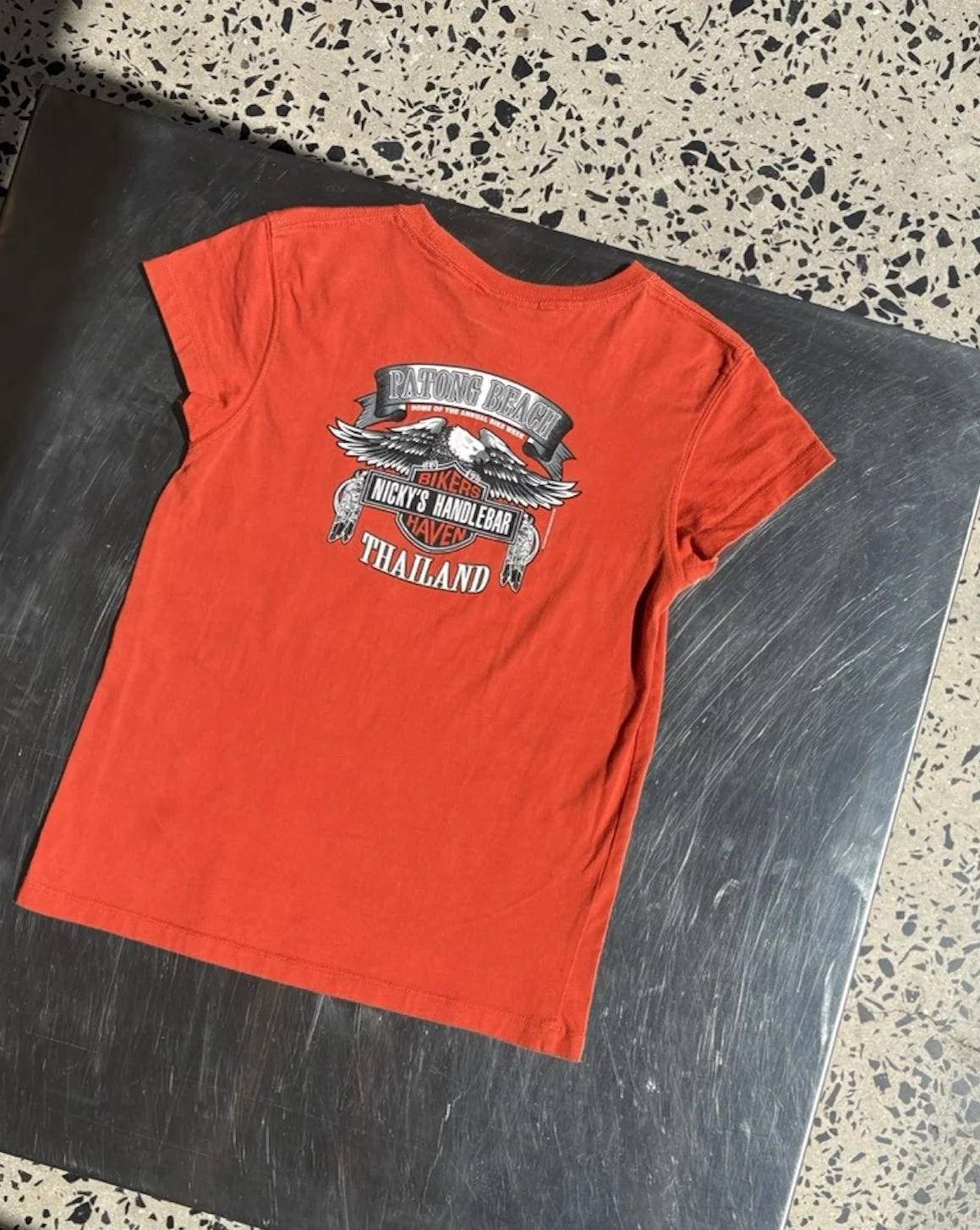 Vintage orange Phuket Bike Week t-shirt laid flat, back view showing winged Patong Beach Thailand print