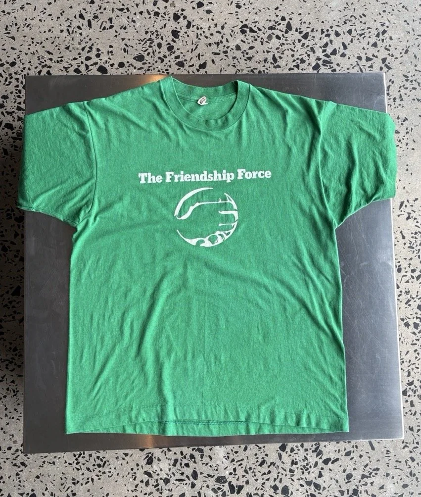 Vintage green Friendship Force t-shirt laid flat, full front view