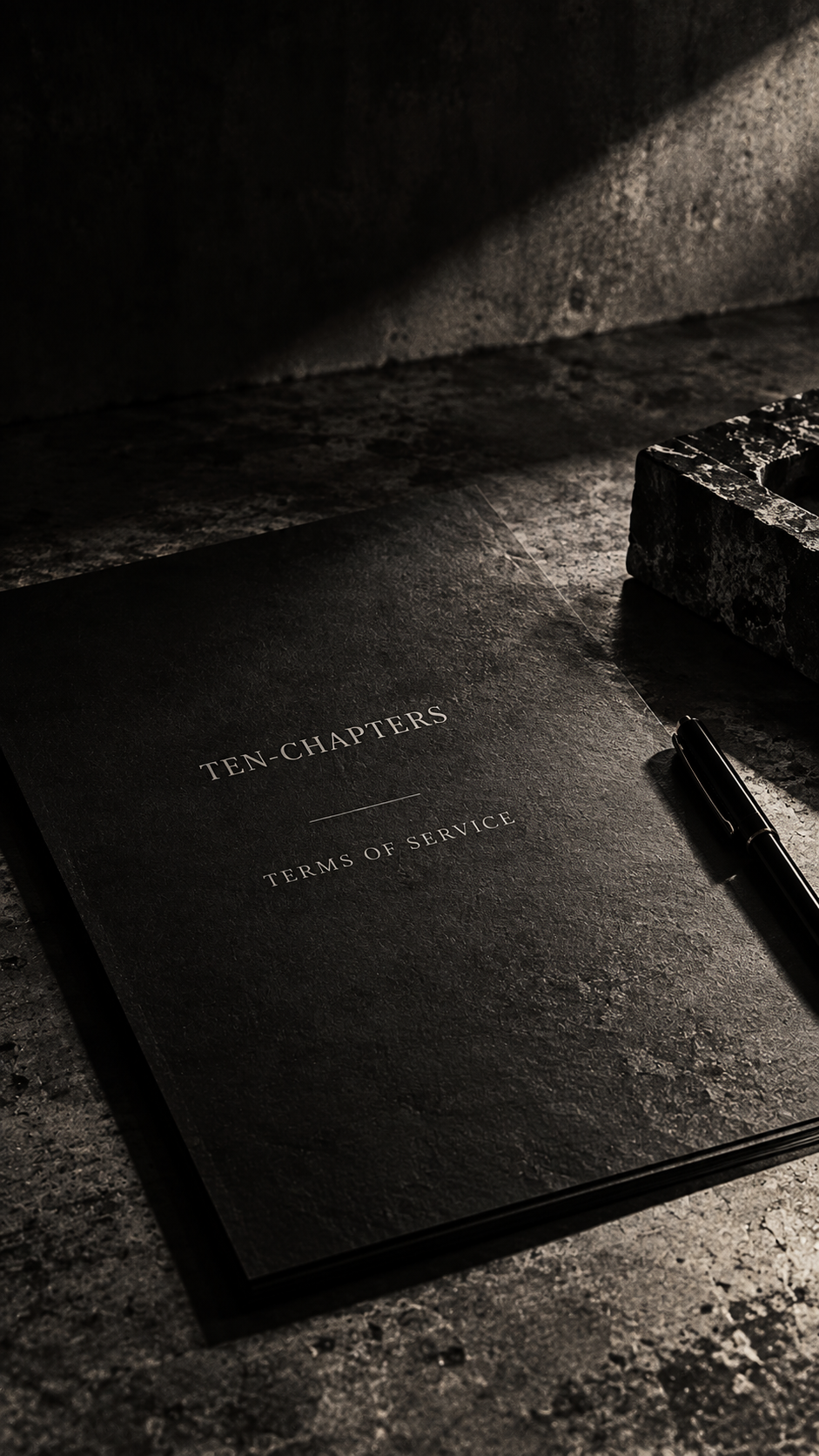 Ten-Chapters Terms of Service document displayed on a dark textured surface with dramatic lighting.