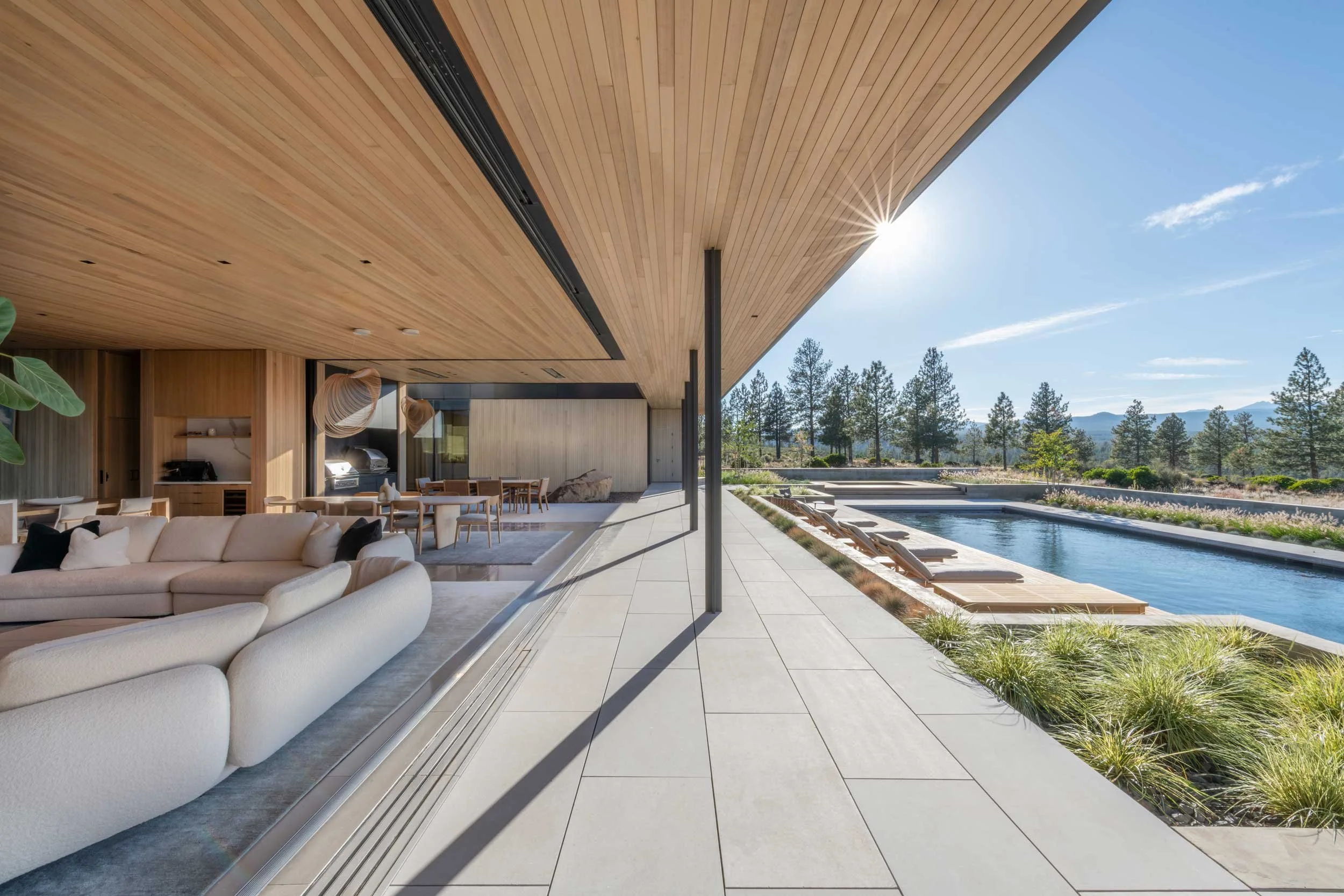 Living space and patio with window wall open to back patio
