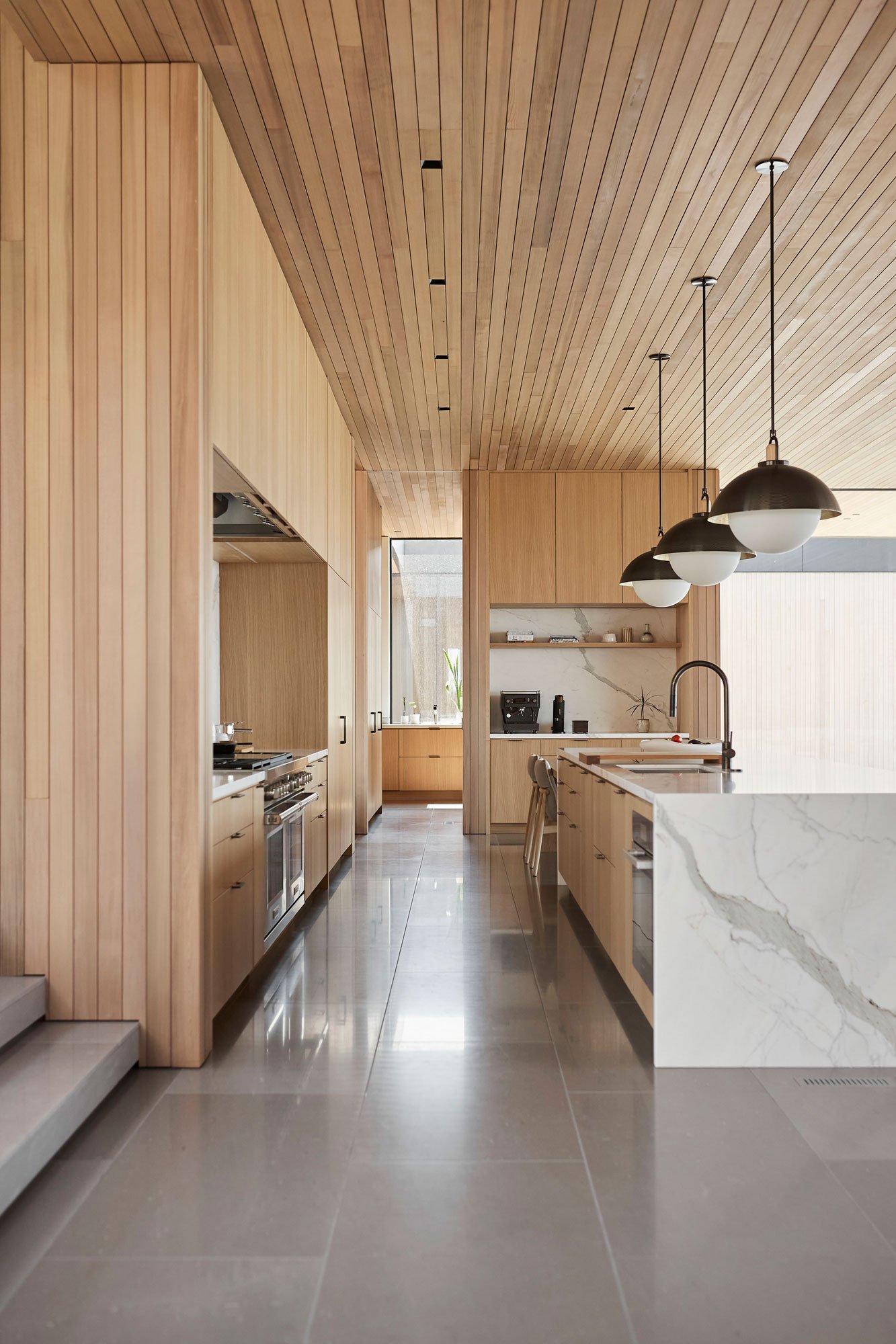 Kitchen alley with light wood cabinetry and walls