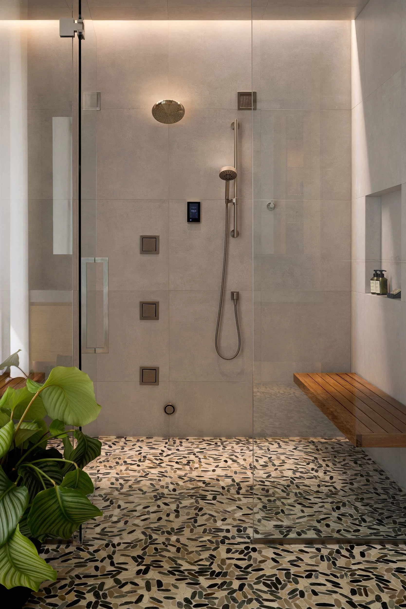 Large walkin shower with gray walls and tiled floors