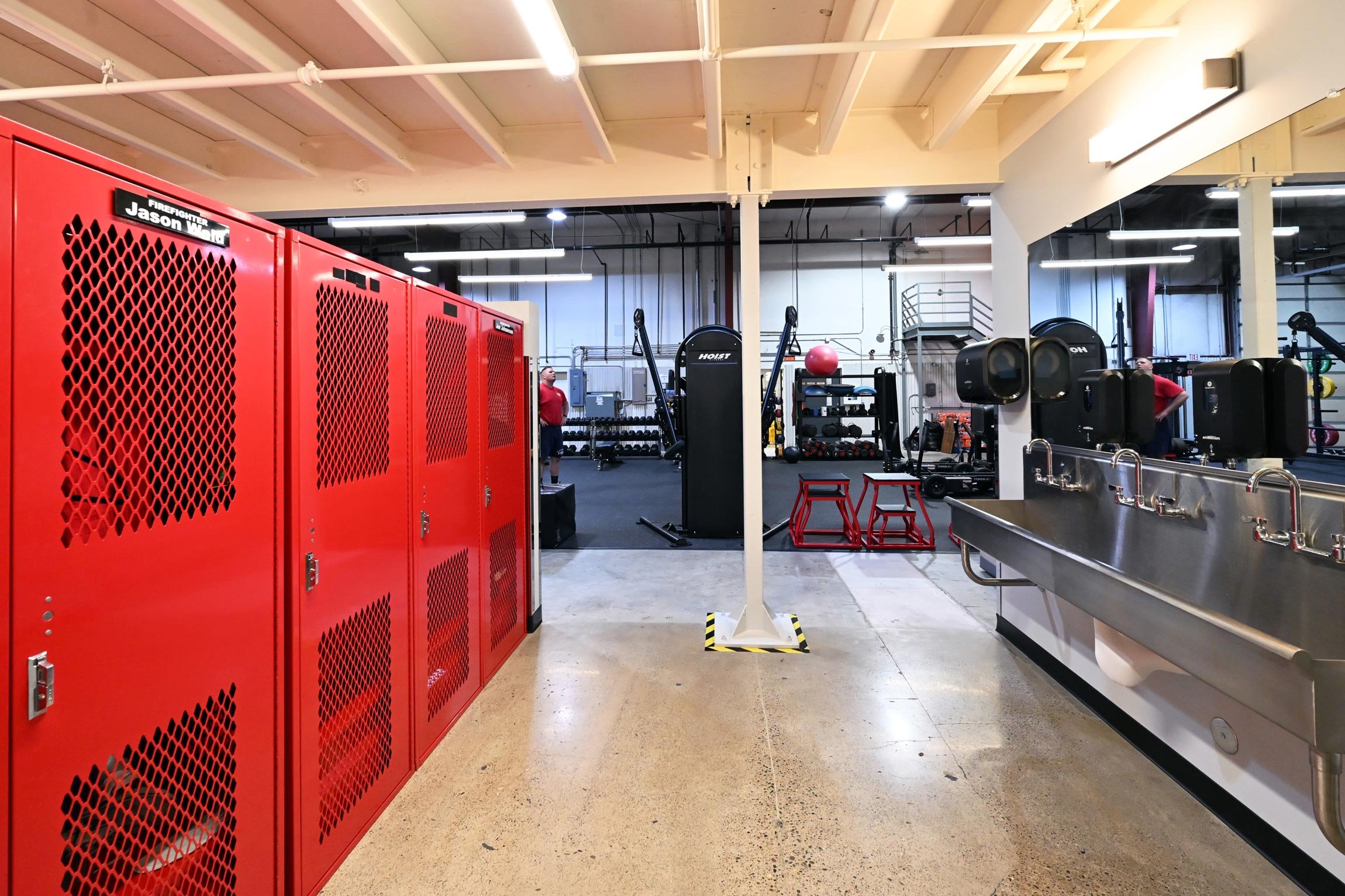 Red lockers in and open sinks in fitness room