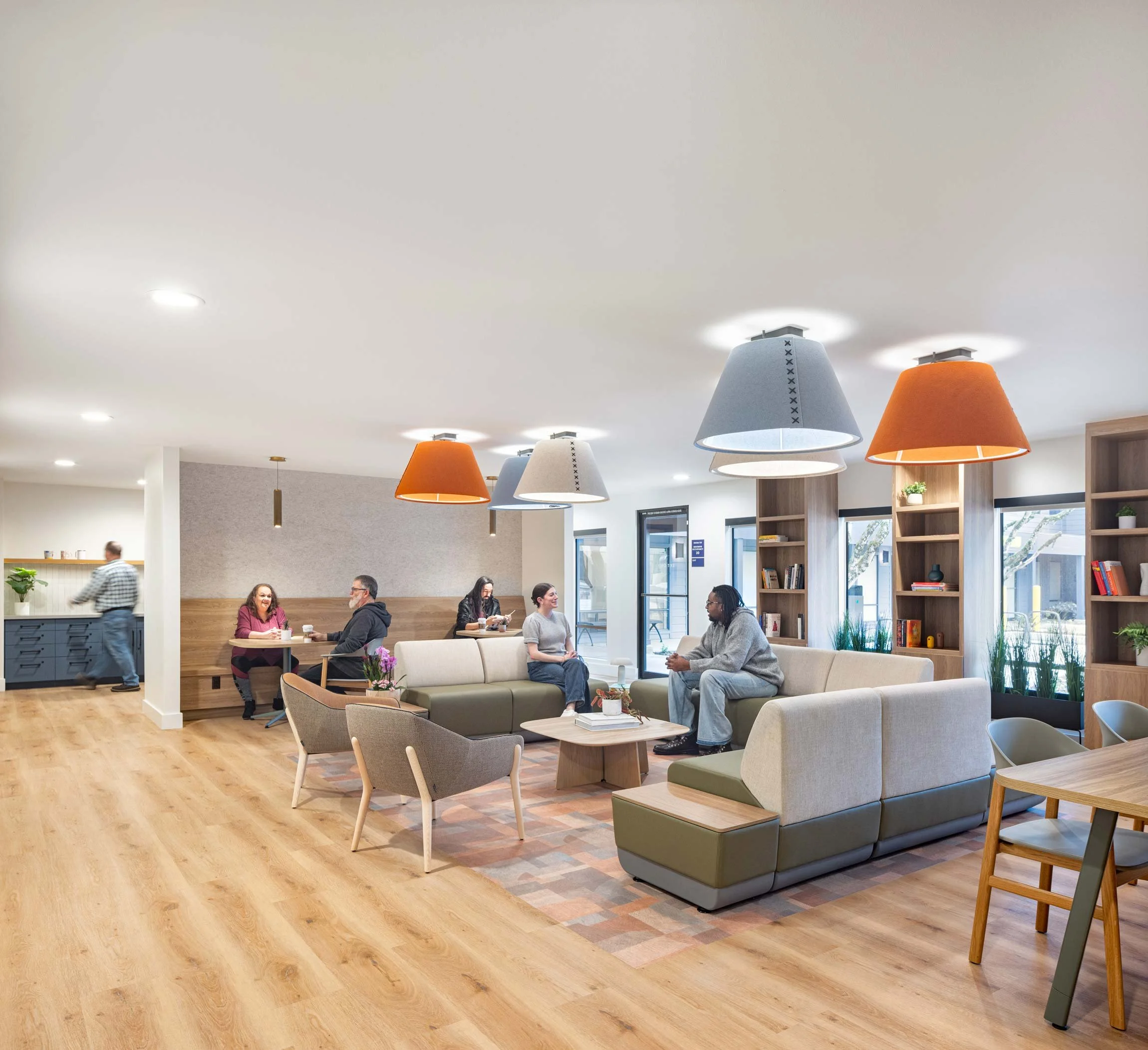 Large lounge space with seating options and colorful feature lighting on ceiling