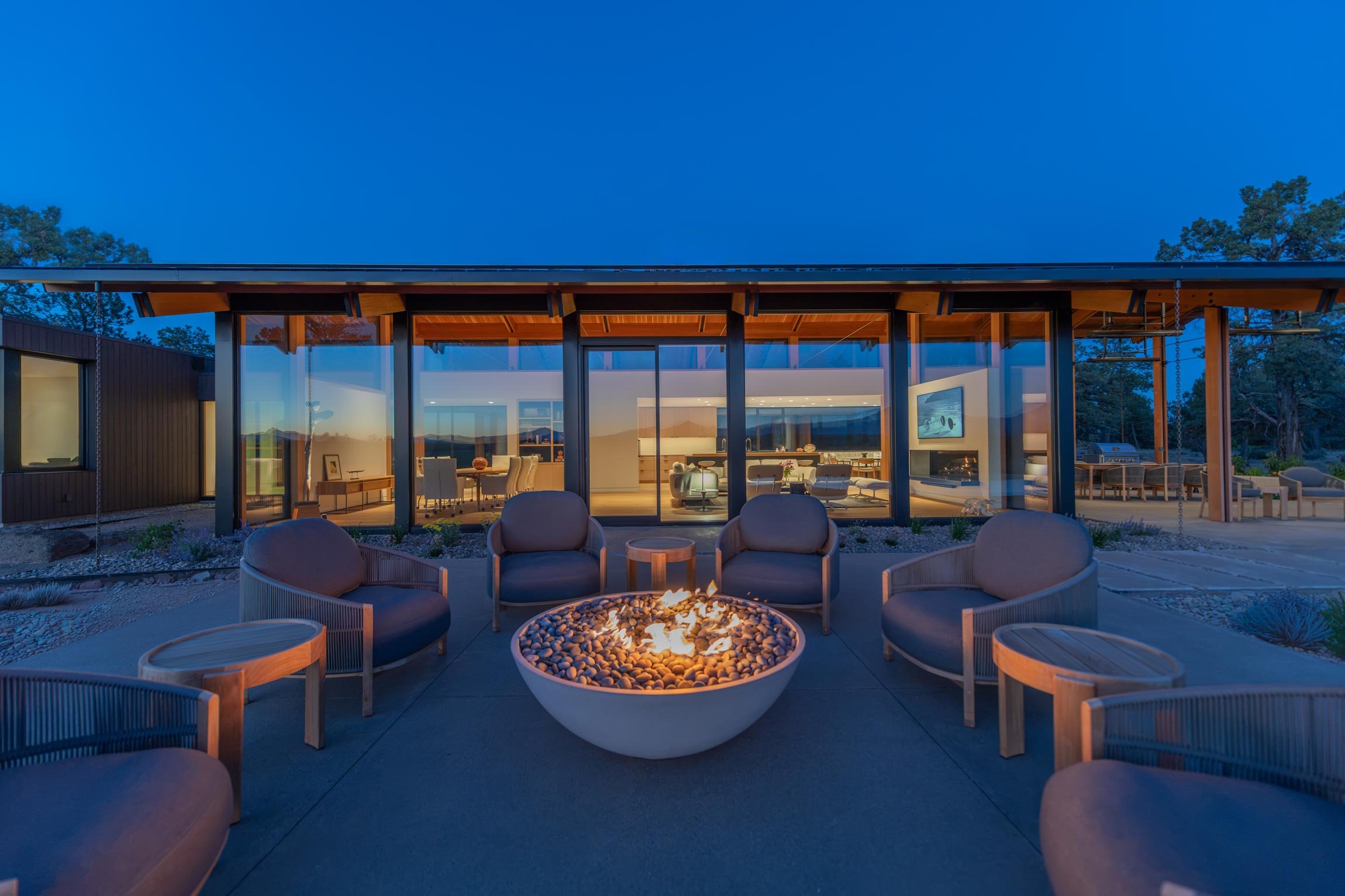 Close up of outdoor fire pit and elevation of inside of house at night