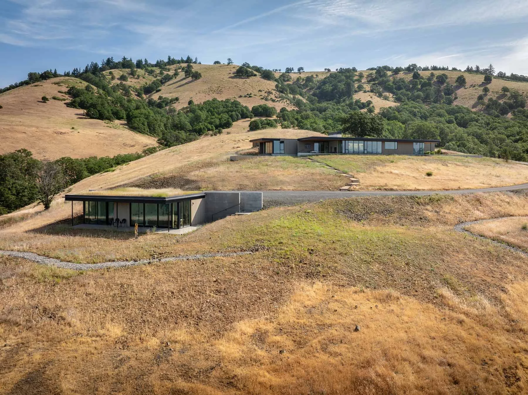 Aerial of two buildings tucked into the side of a hill