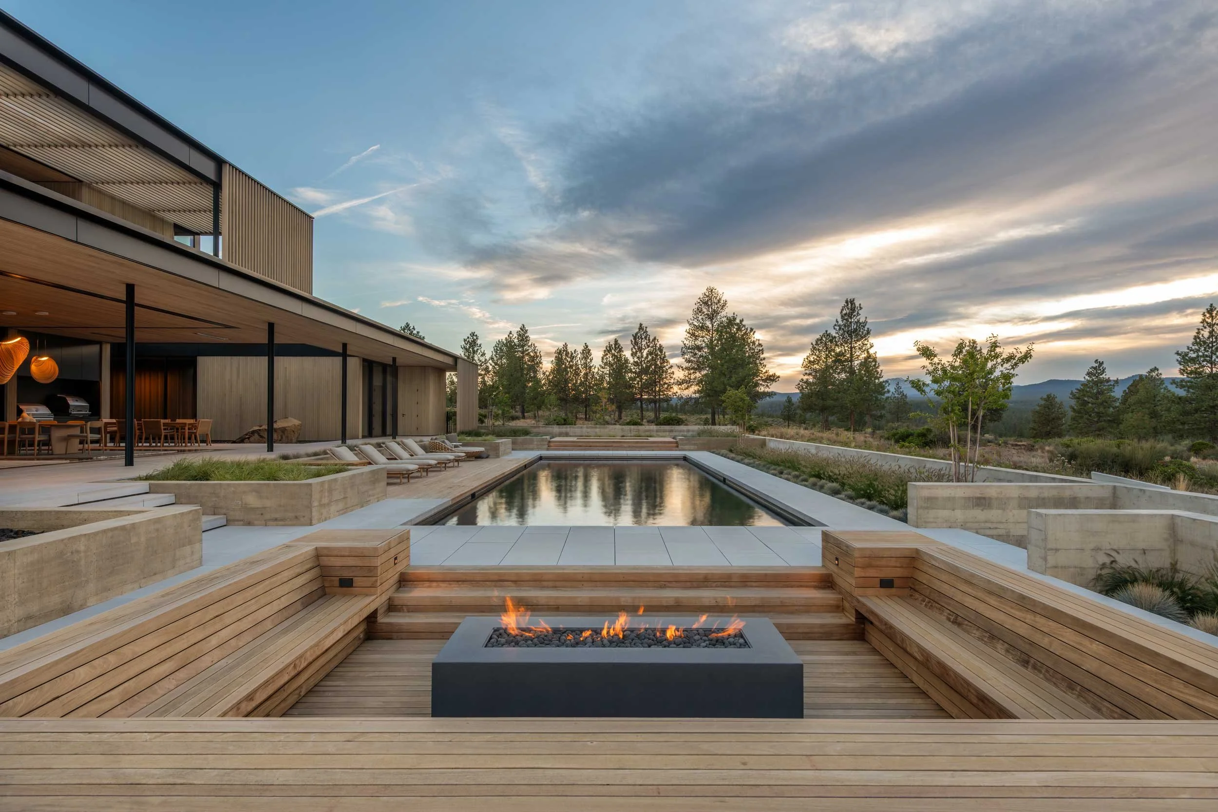 Backyard fire pit with built in seating and pool behind