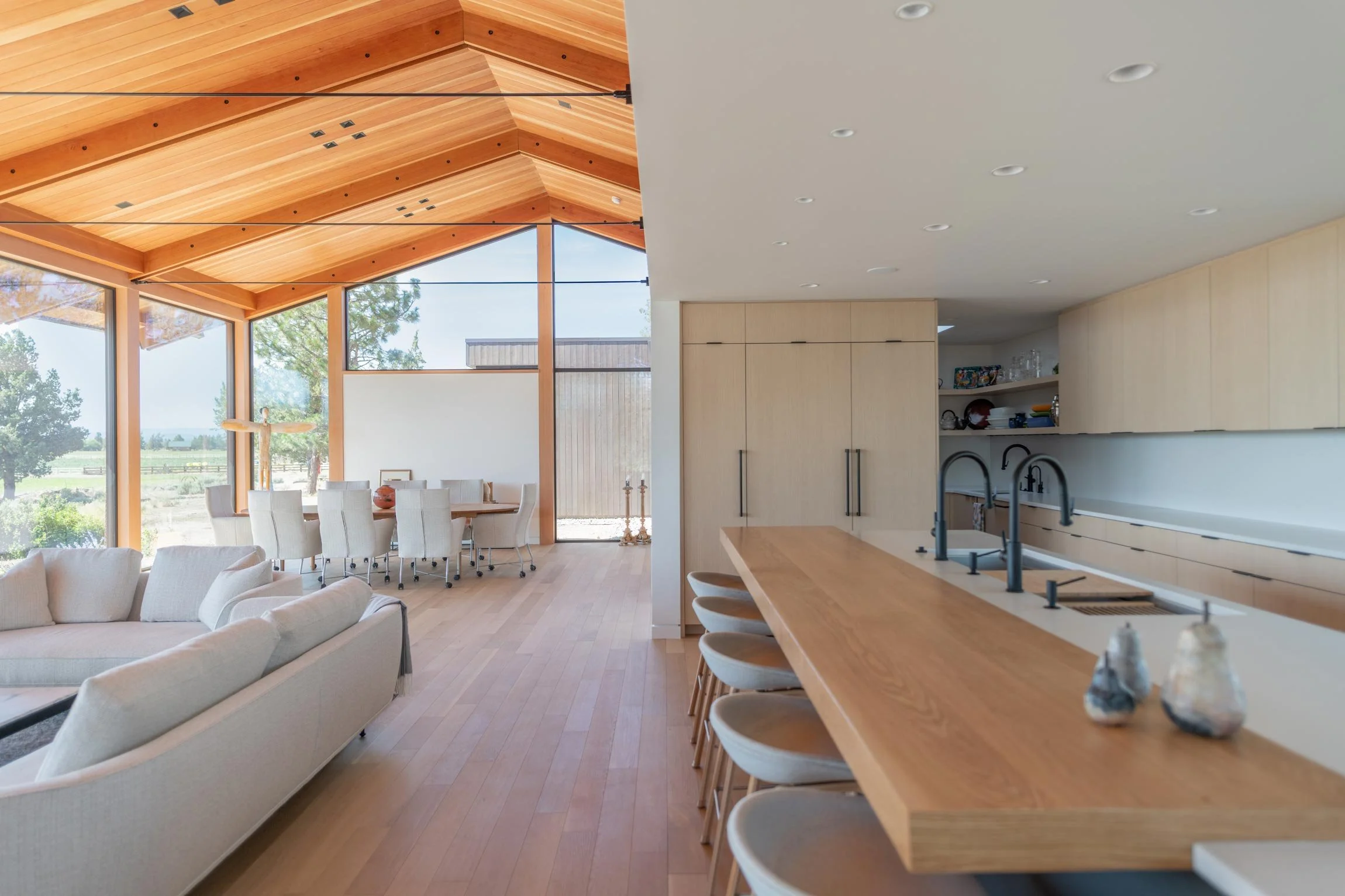 Living room and kitchen facing floor to ceiling windows