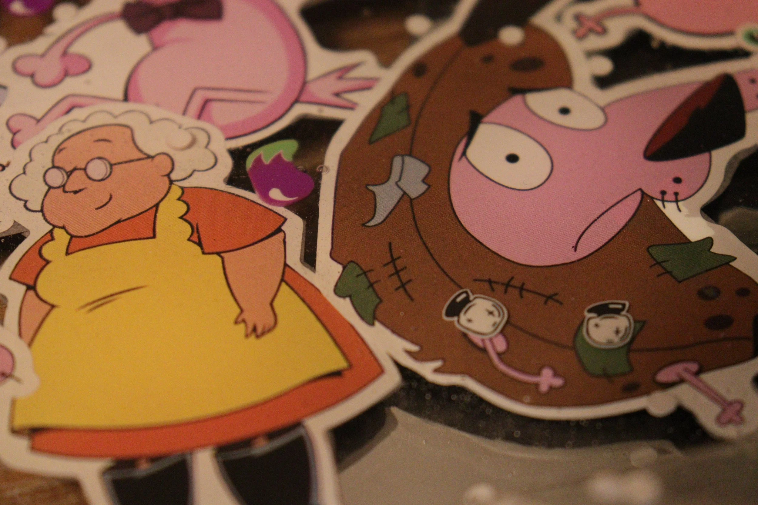 Colorful cartoon stickers featuring characters like a pink pig with a graduation cap, a brown bear with a bow tie, and a character with glasses and curly hair, among other whimsical figures and objects.