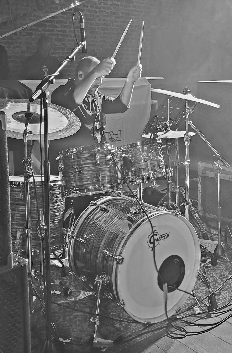 Een jonge drummer speelt op een drumstel met een microfoon in een geluidsstudio.