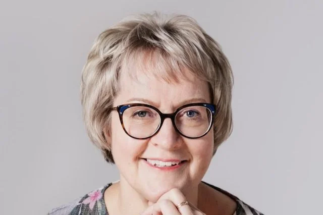 Henkilö katsoo ikkunasta ulos, silmät hieman hymynkareessa ja pää hieman kallellaan oikealle.