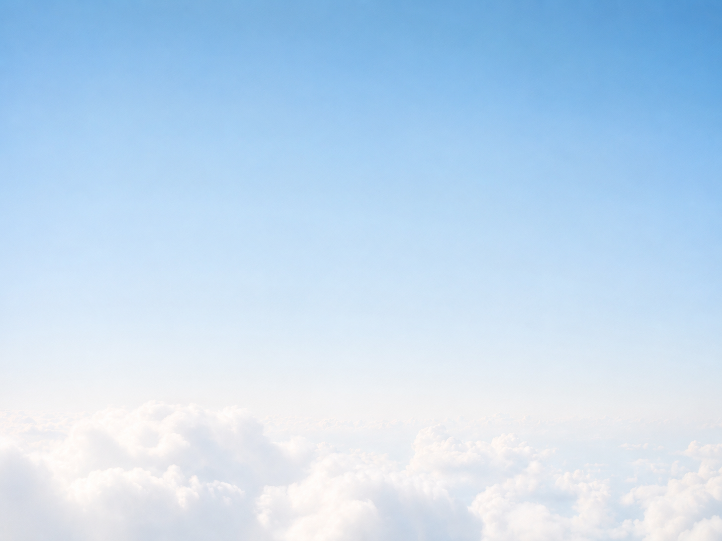View of blue sky above white clouds.