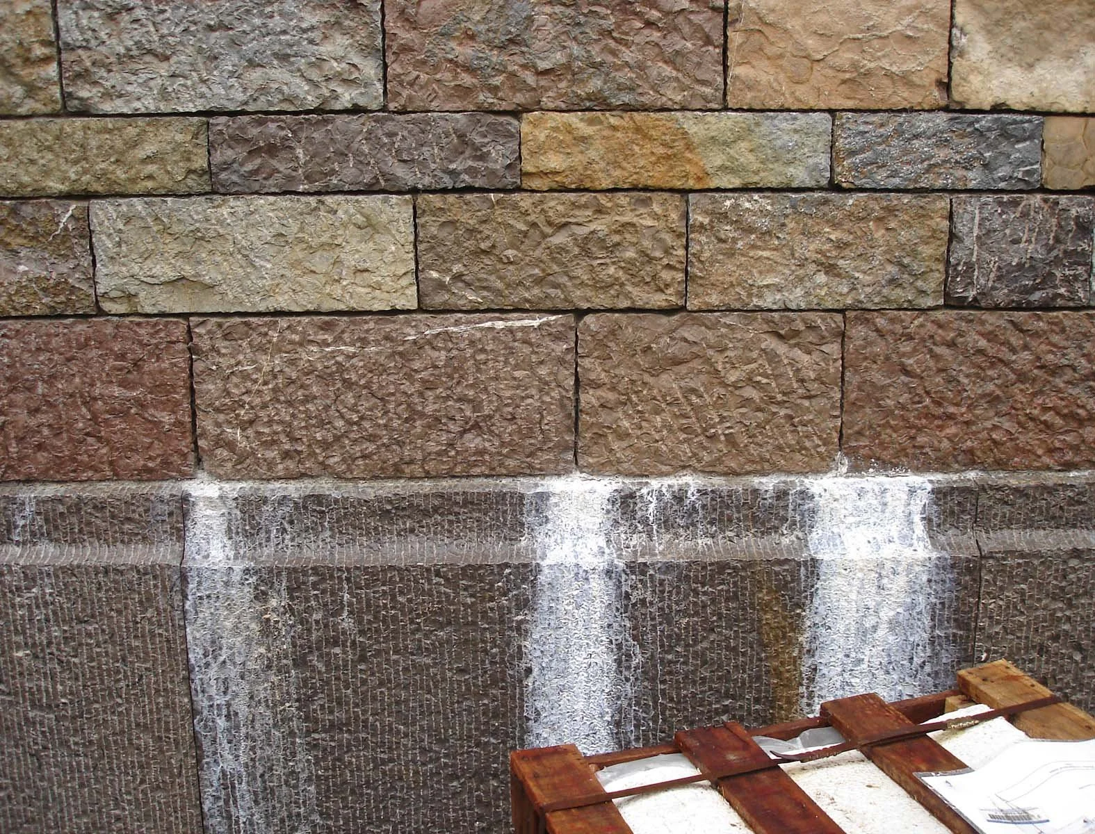 Newly constructed limestone wall with white mineral runs