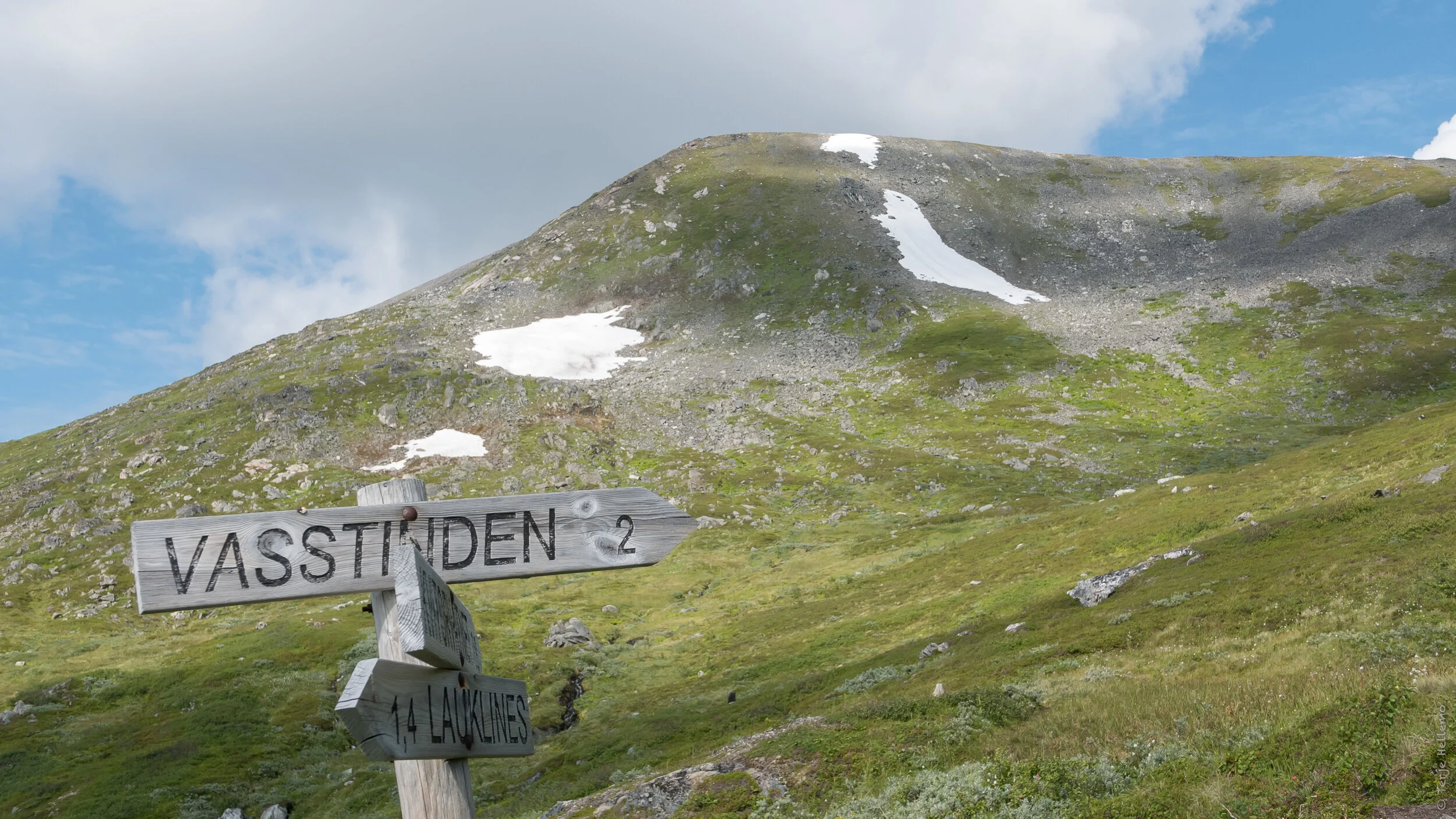Vennlig skilting på veien. Vi skal opp på toppen bak den haugen vi ser.