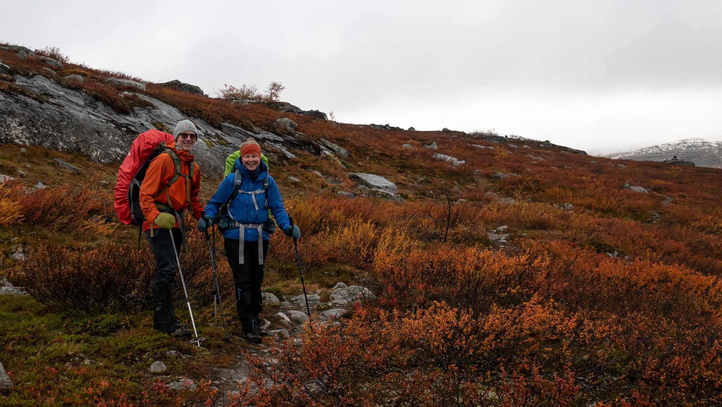 Reidar og Kristin på vei opp fra vegen ved Galggojávri. Vi passerer Bossovárri, som er kledt i rødt med masse fin dvergbjørk.