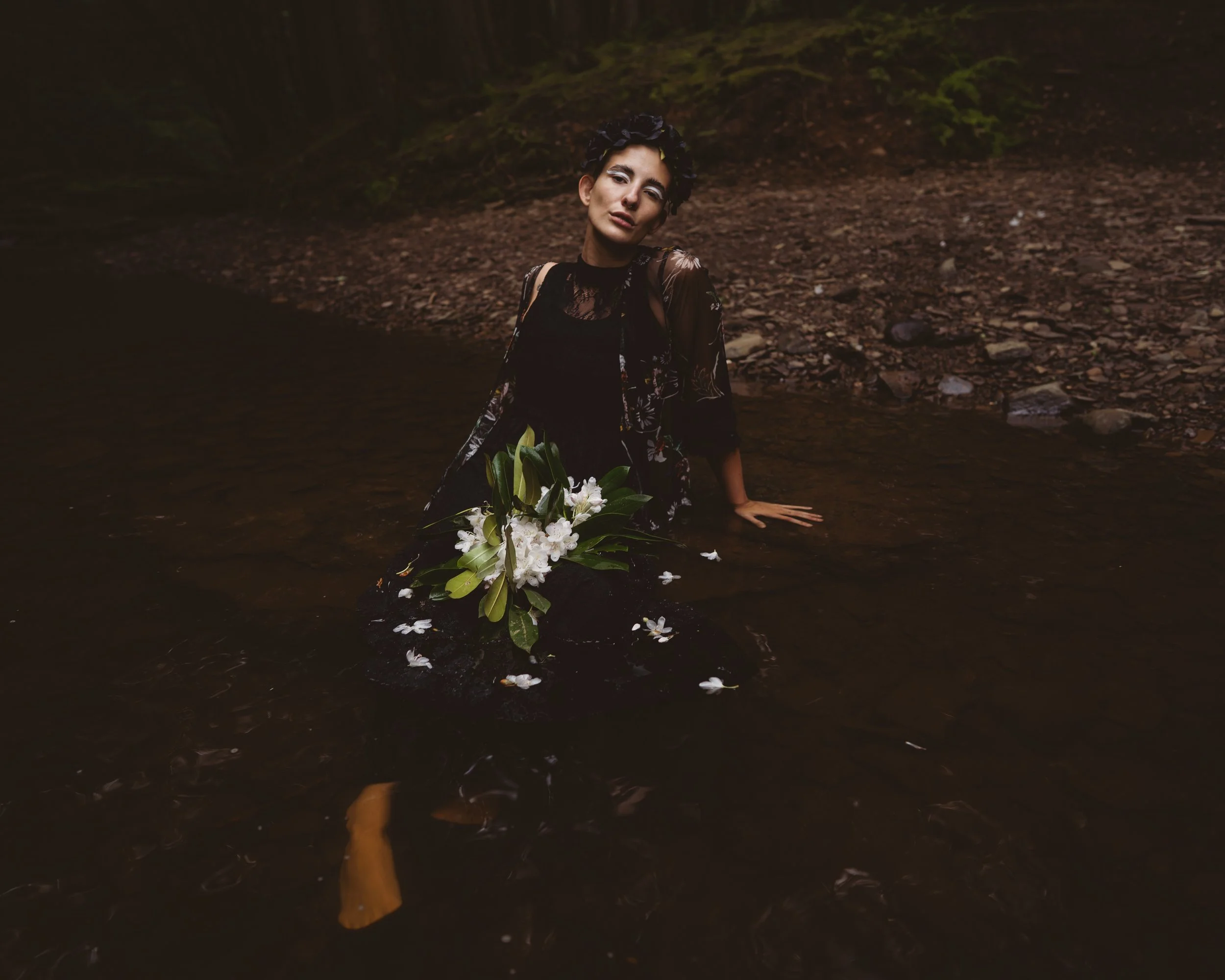 person sitting on creek edge as slavic witch