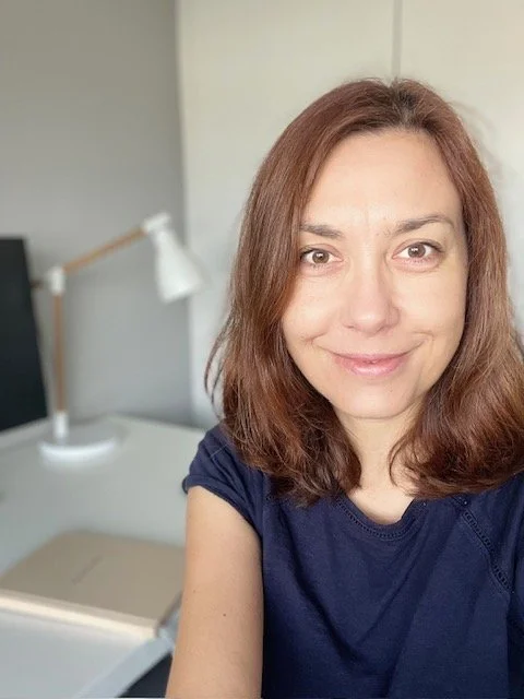 Ella, a Squarespace web designer sitting at her desk and smiling