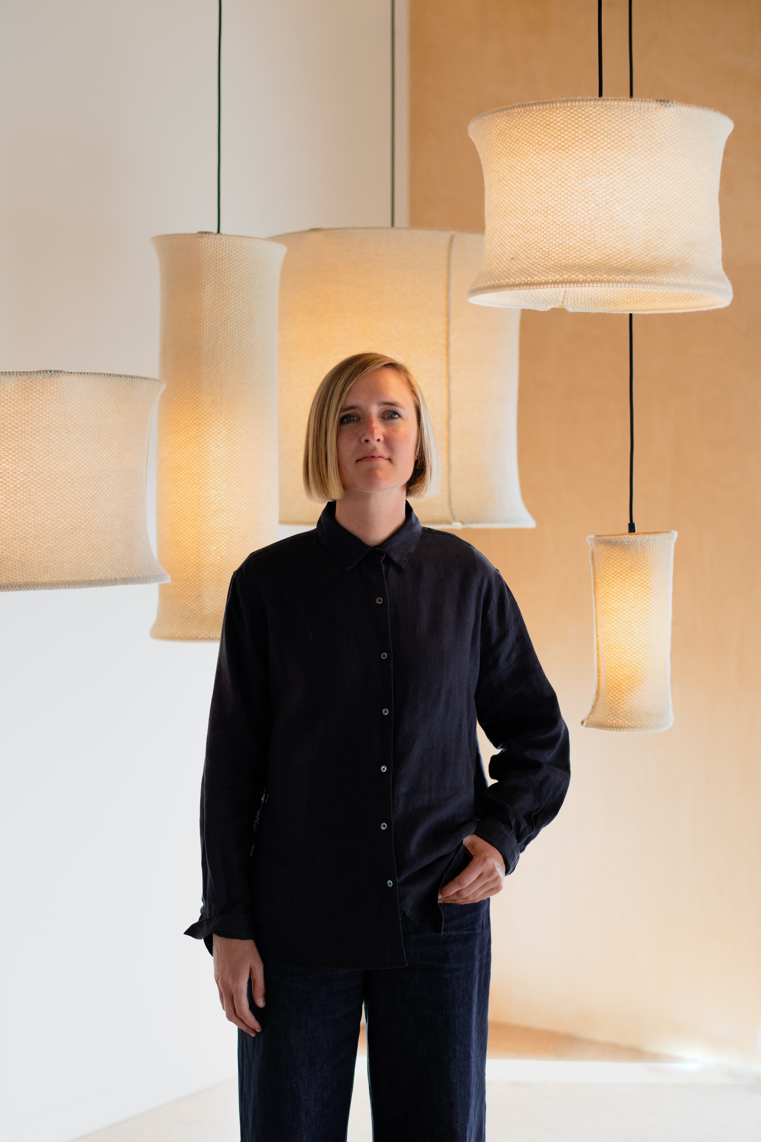 Sophie Poelman with Wool Hoop wool pendant lights in studio, New Zealand–made acoustic lighting